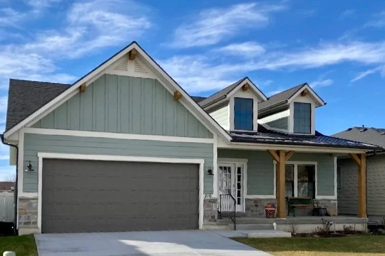 New construction home with light gray painted siding, white exterior trim, and a matching garage door.
