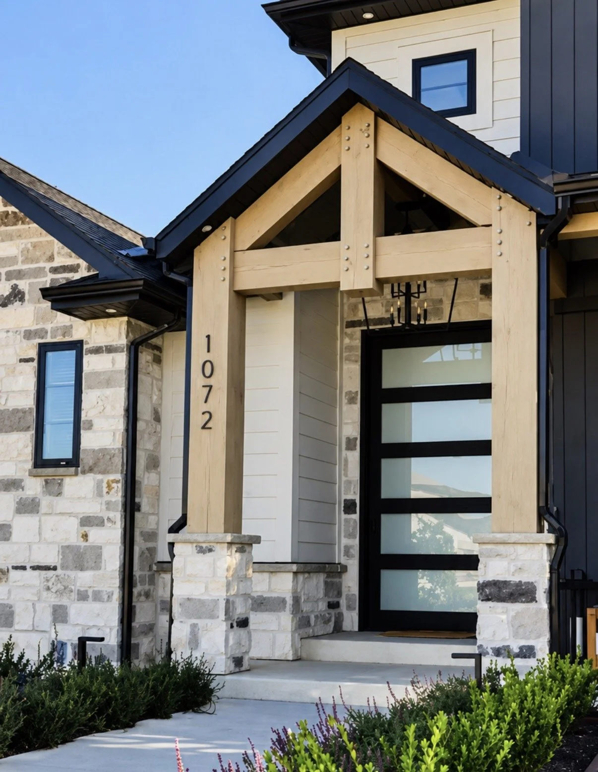 Custom timber gable accent framing the front entrance of a modern home with stone masonry