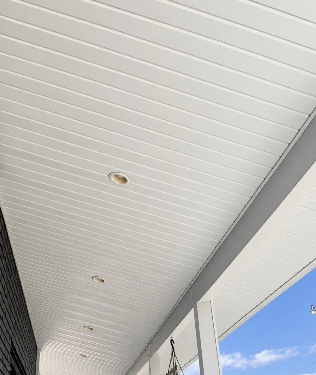 Sloped white aluminum soffit porch ceiling