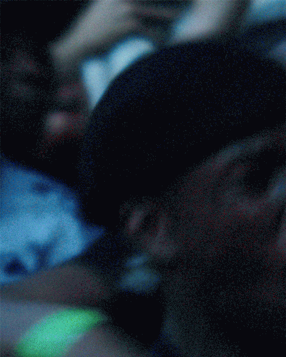 Person wearing sunglasses and a headband, close-up shot in a dimly lit environment.