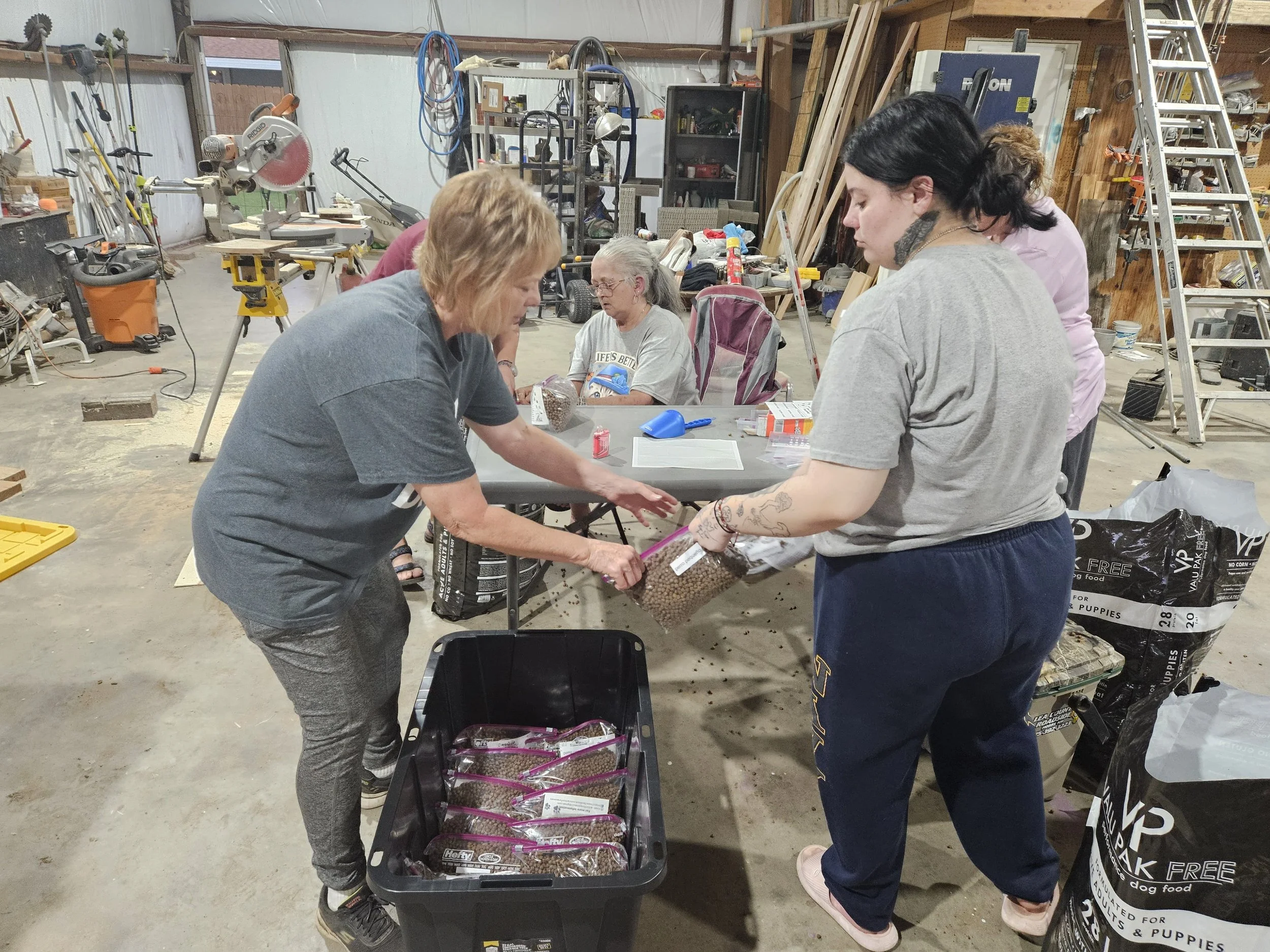 People in a workshop filling bags with dog food.
