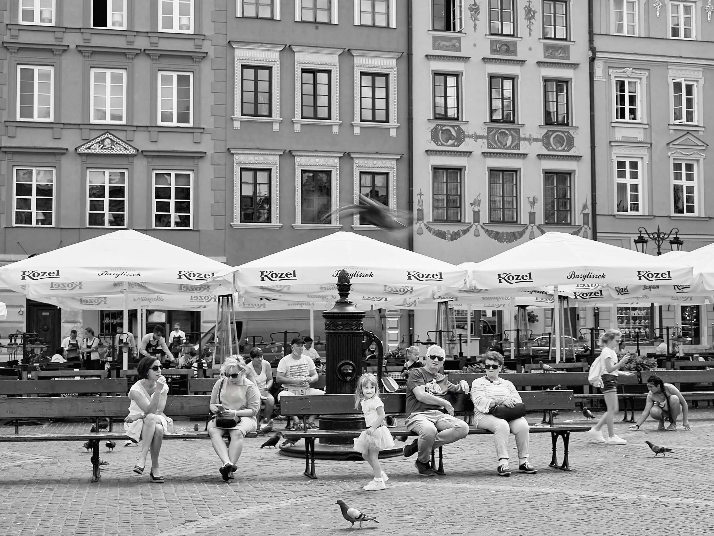 Little girl playing in the streets of Warsaw surrounded by people.