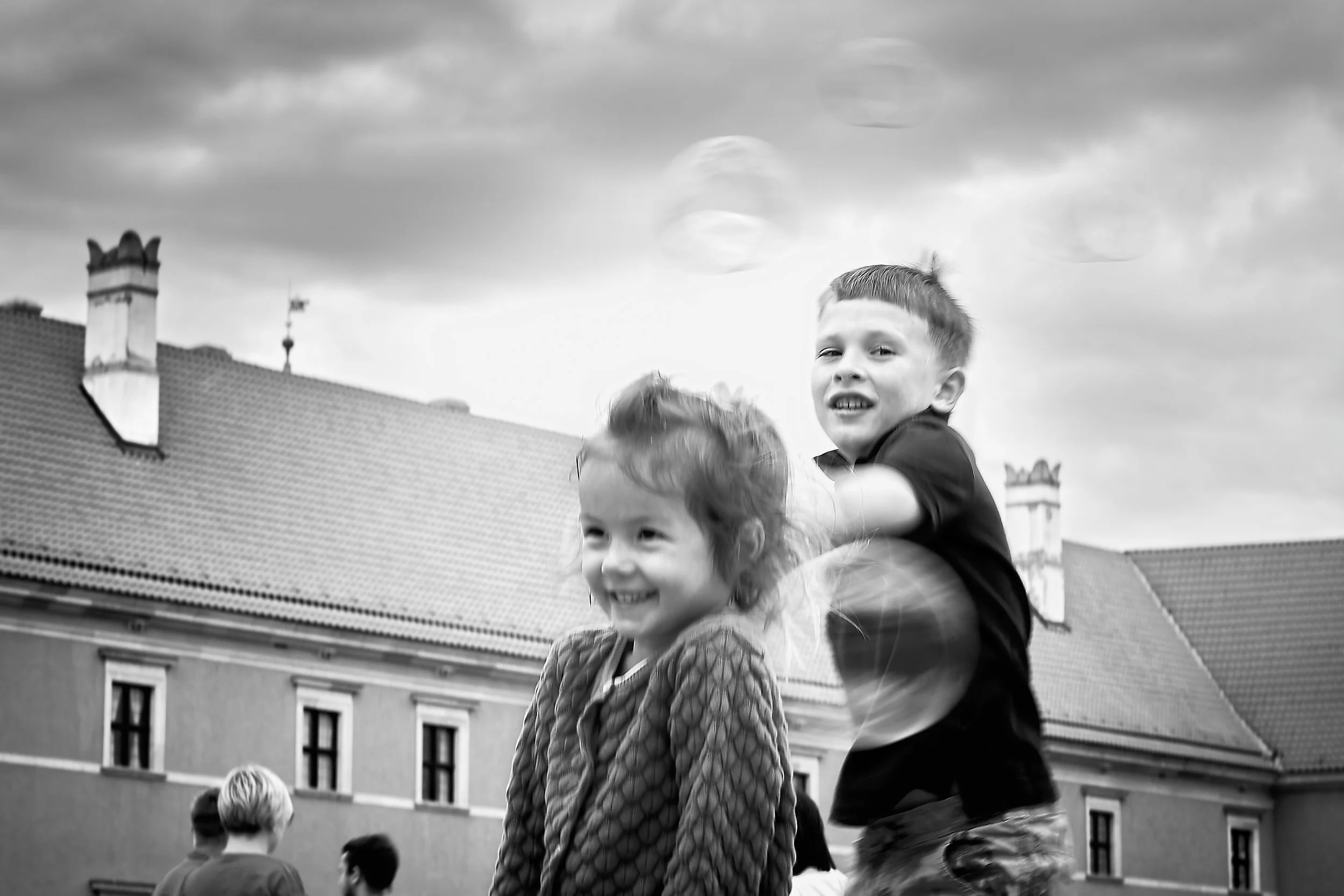 Children playing with bubbles in the square.