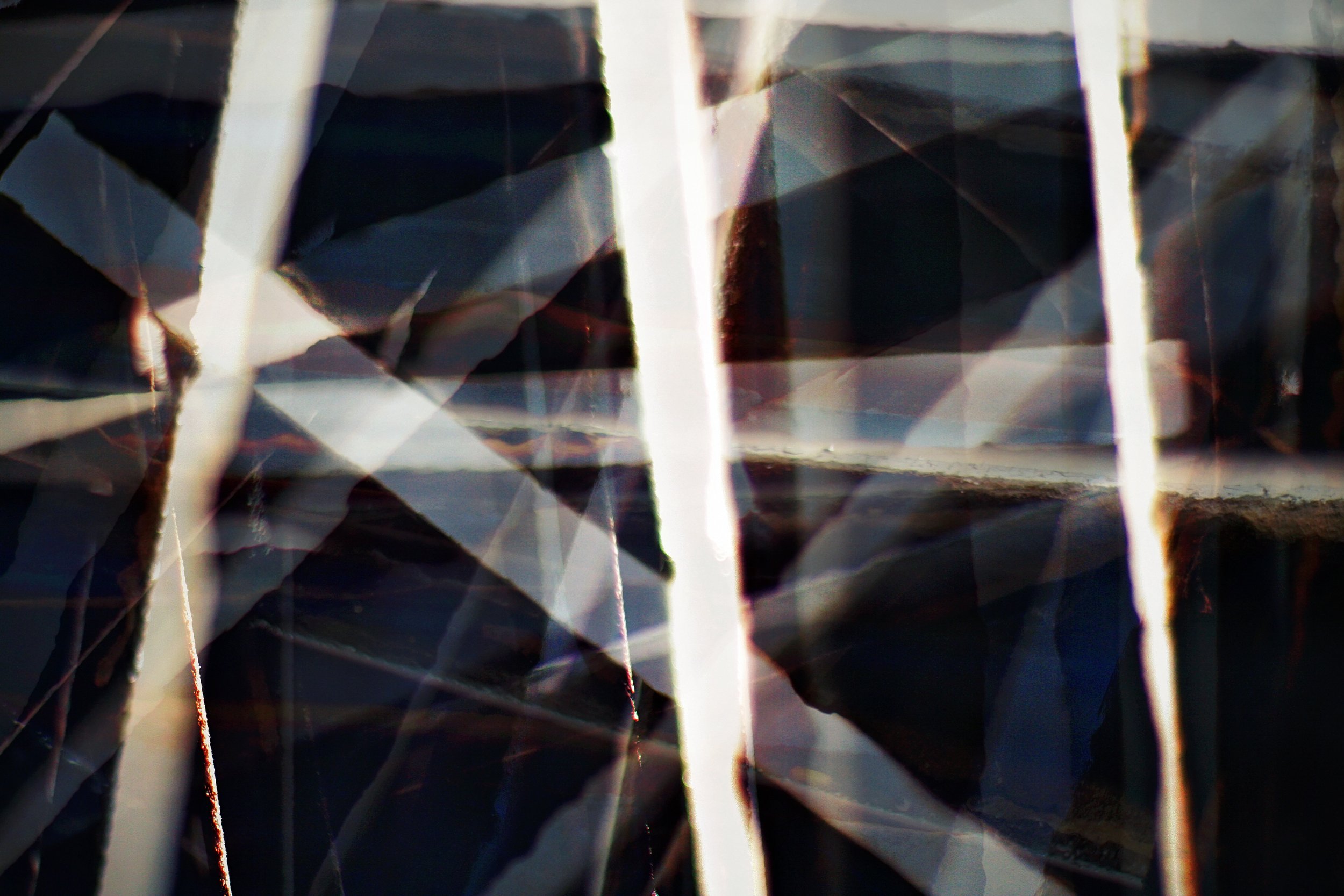 Close-up of a diamond-shaped gemstone with a faceted surface, reflecting light and creating colorful reflections and patterns.