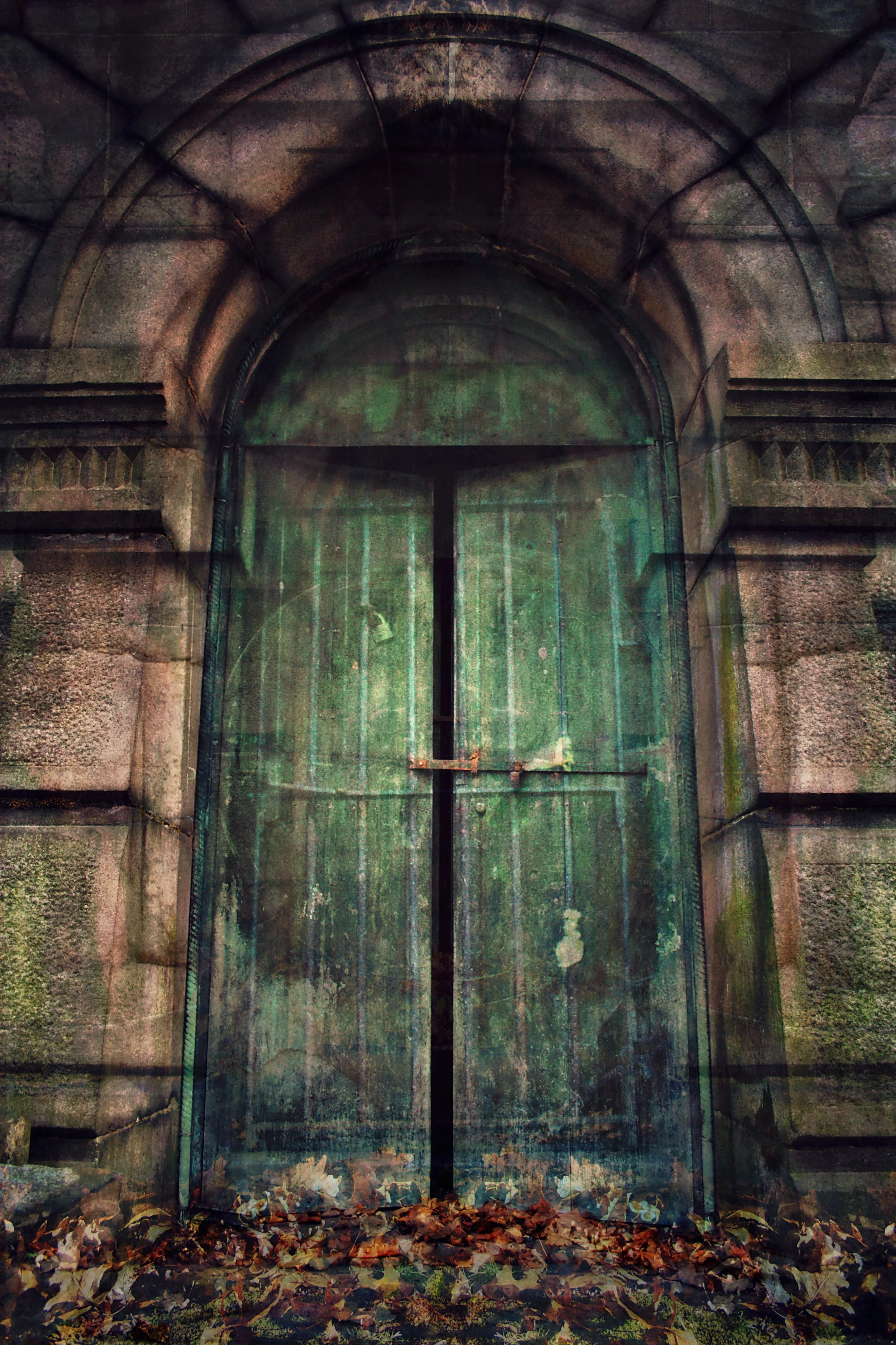 A weathered, green metal door set in an old stone wall, surrounded by fallen autumn leaves.