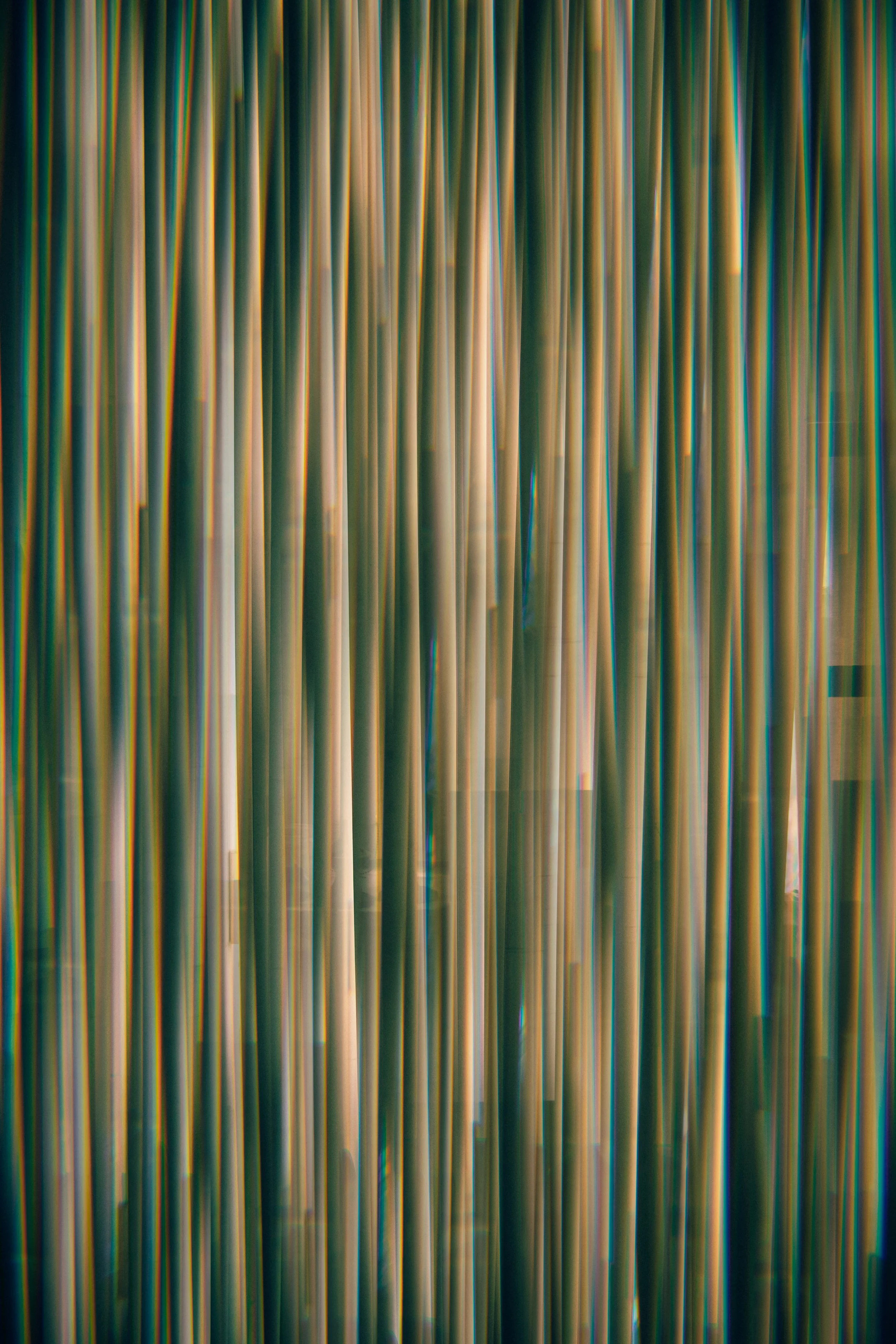 An abstract image of colorful vertical streaks and lines with a blurred, flowing pattern.