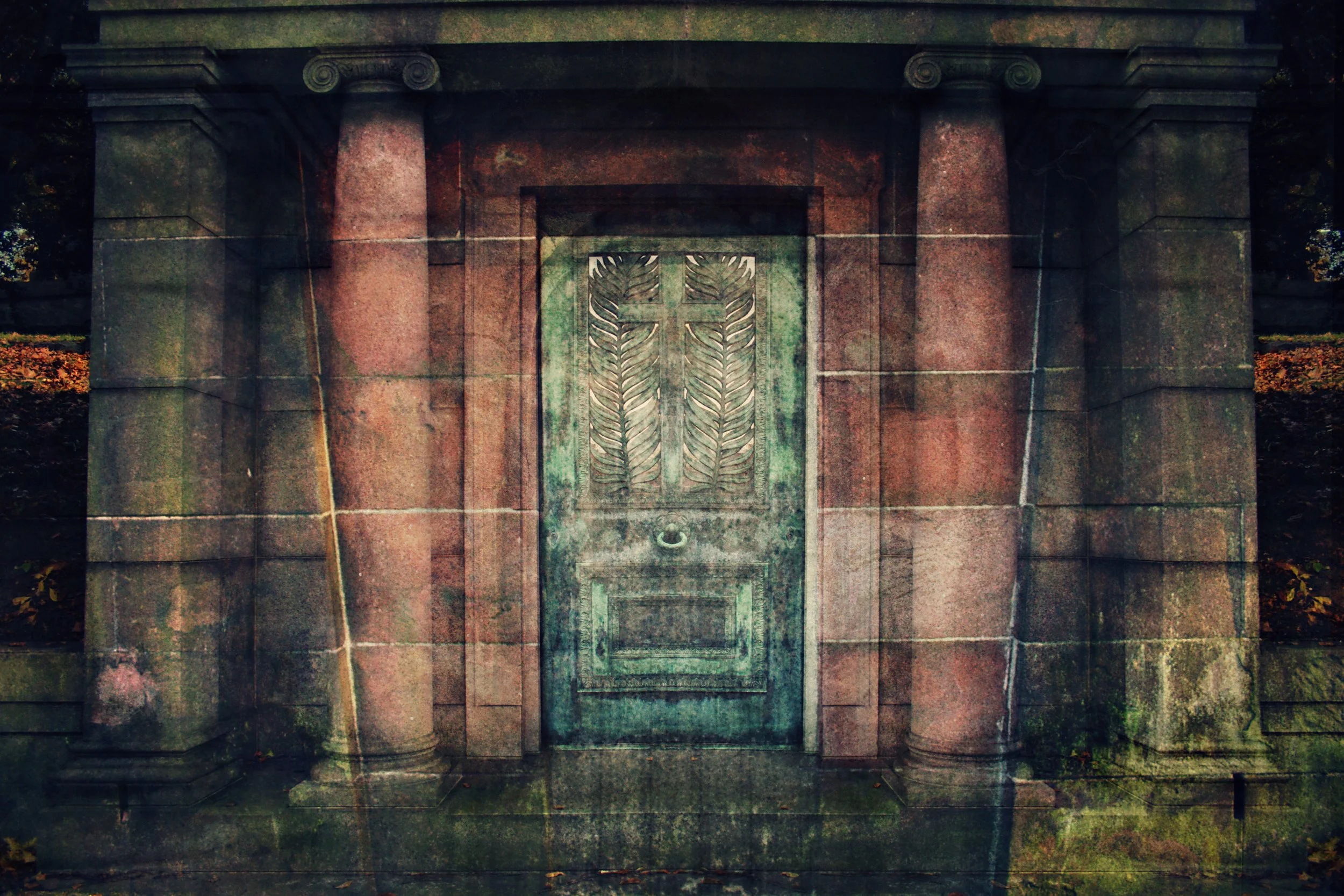 A stone entrance with two columns and a decorative metal gate featuring a cross and leaf design, set in a cemetery or memorial site surrounded by fallen leaves.