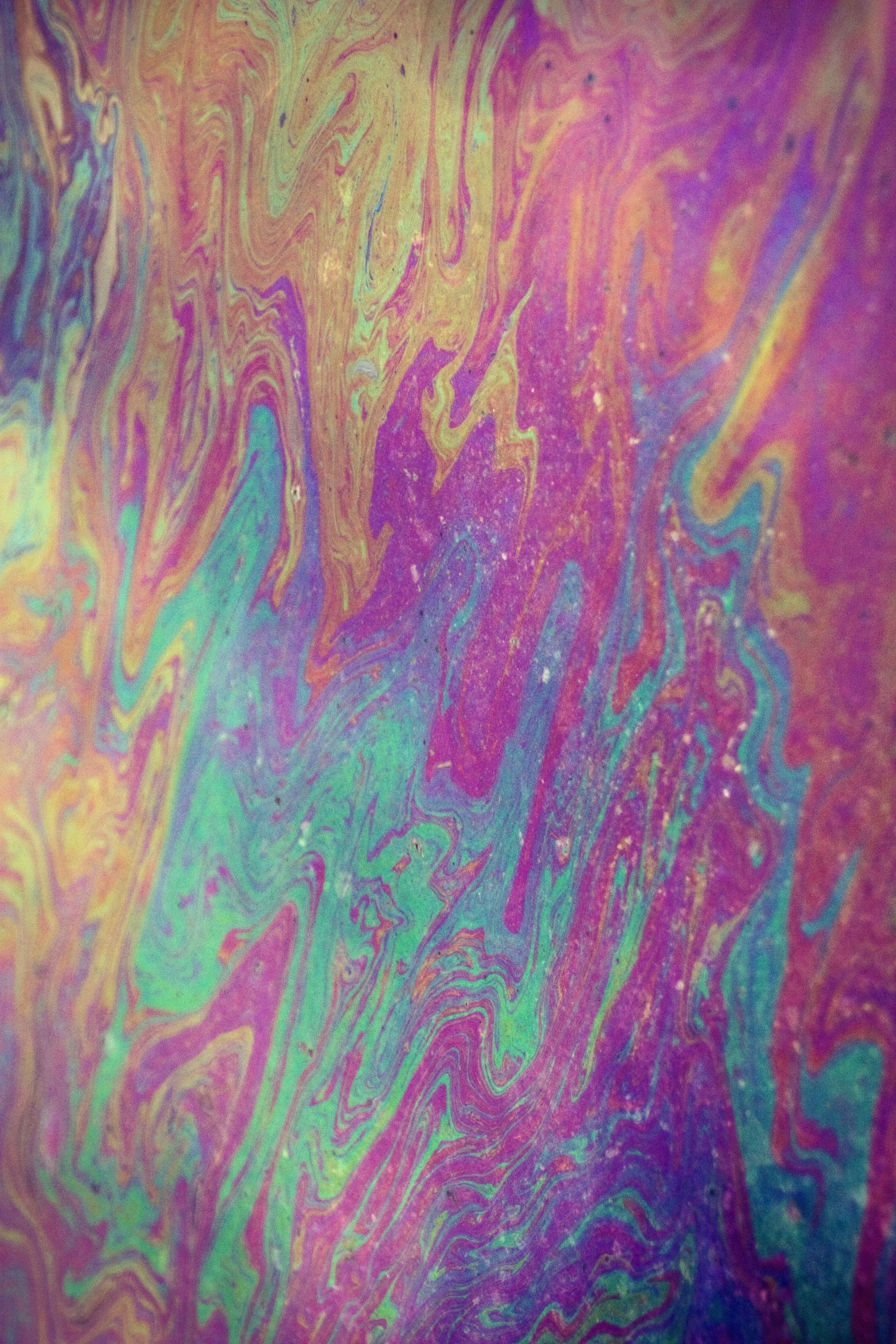 Close-up of colorful swirling soap film with rainbow iridescent surface and intricate patterns.