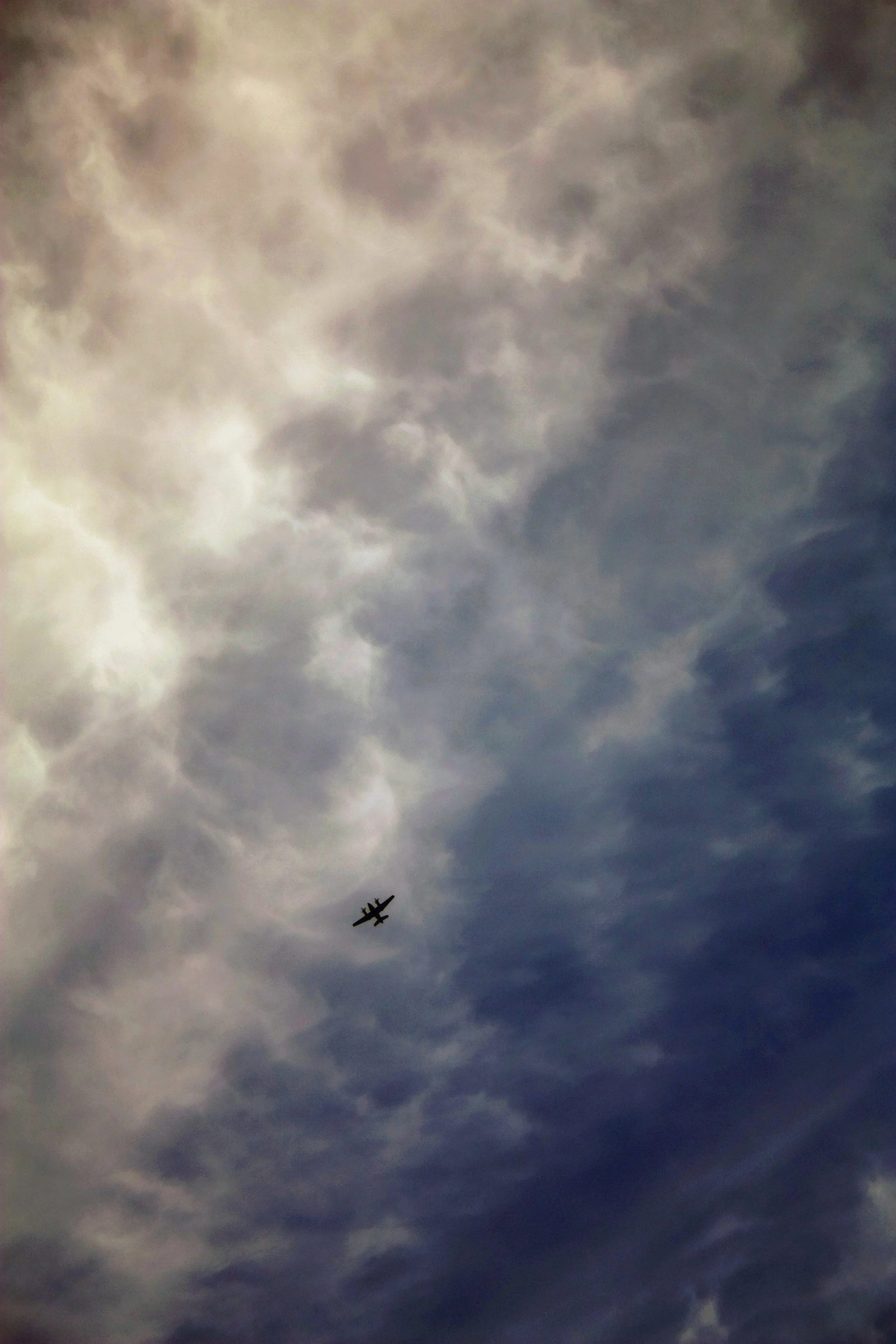 A small airplane flying in a cloudy sky.