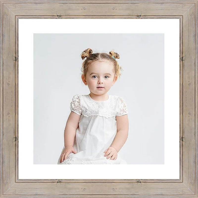 Little girl in white looking at the camera