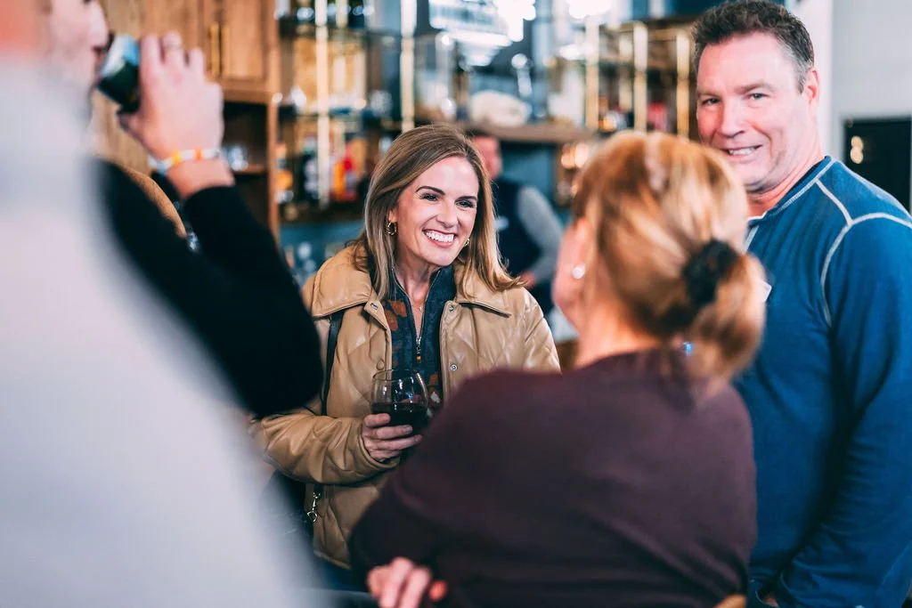 People socializing at a bar or restaurant, smiling, and talking.