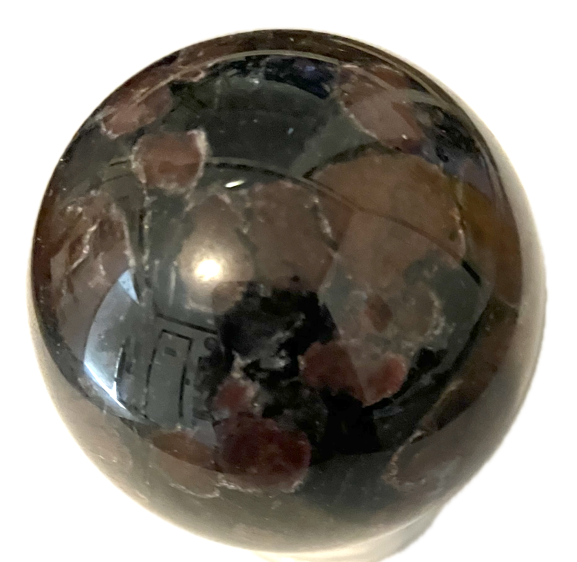 A shiny crystal stone that has a base color of black with red splotches all over its surface.