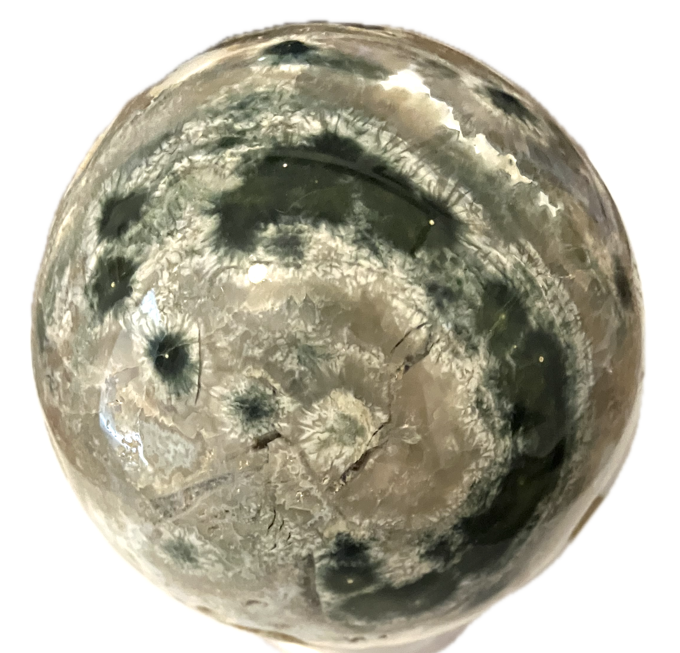 A polished crystal stone that is mostly white with a green circle on its surface.