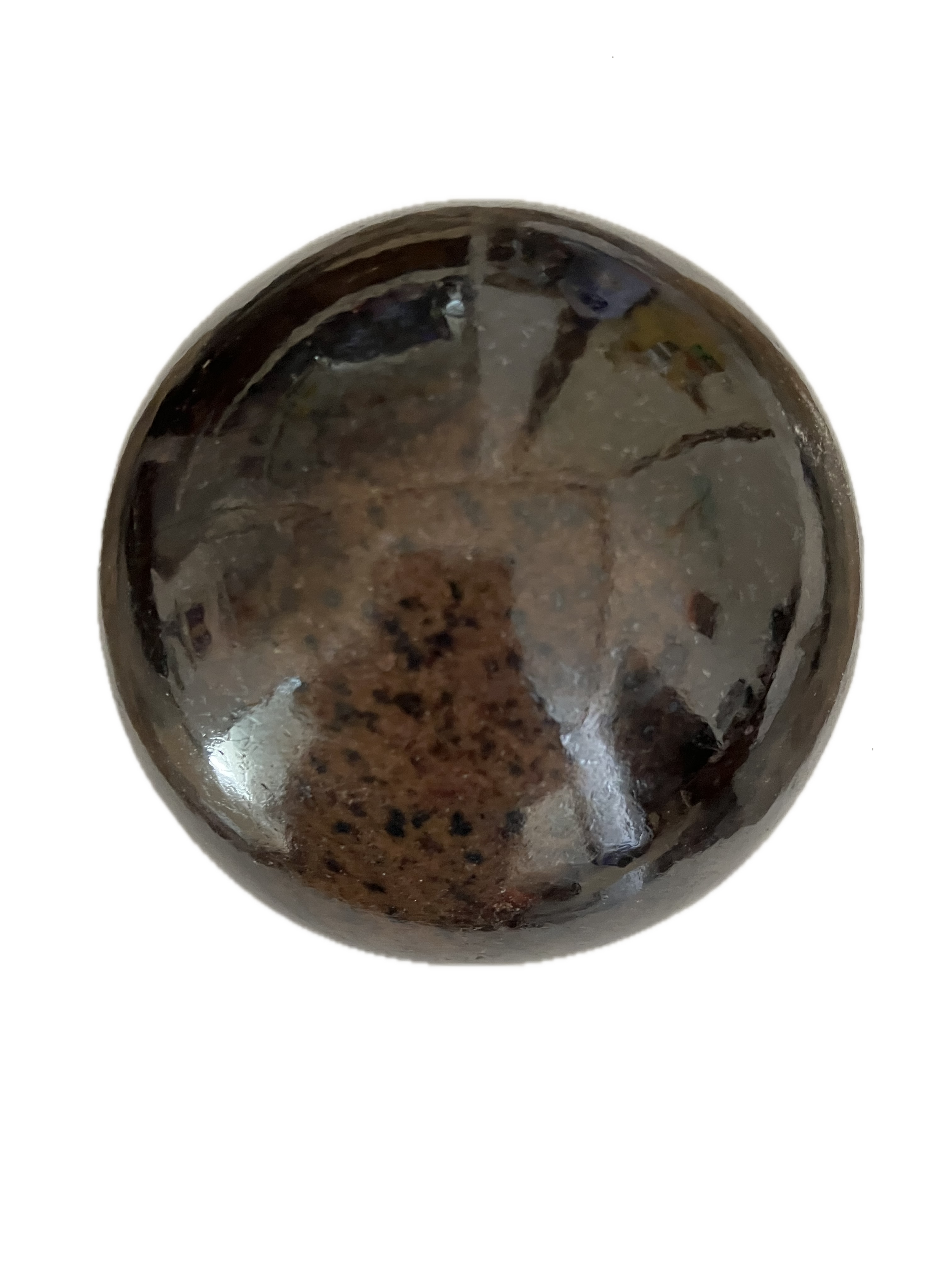 A crystal stone that is mostly brown but has a little black on it. It is shiny and reflecting the light.