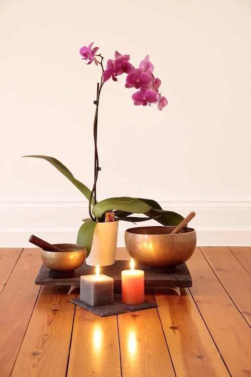 Orchid, singing bowls, candles in a meditative arrangement, vibe of Seasonal Sync, Lori Cangilla, Singularly Sensitive