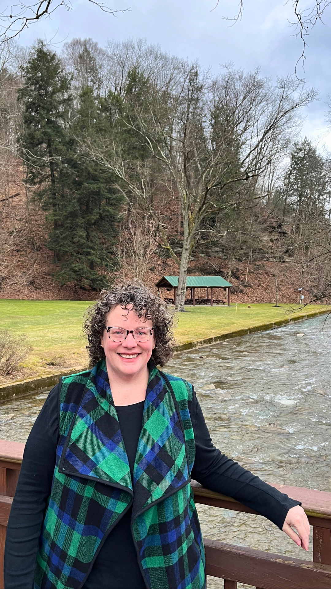 Creator of Gentle Joy Sensitive Women's Leadership Collective Lori Cangilla from Singularly Sensitive pictured on a bridge by trees during a forest therapy walk