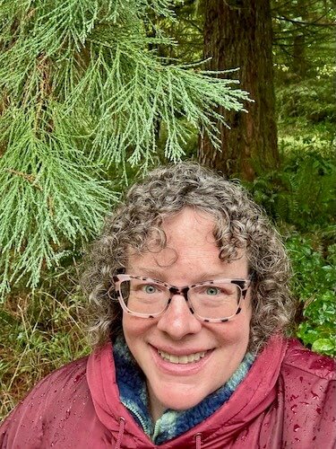 Lori L Cangilla PHD licensed psychologist certified forest therapy guide (CFTG) mentor coach author in a rainy cedar grove on a forest therapy walk near Portland Oregon