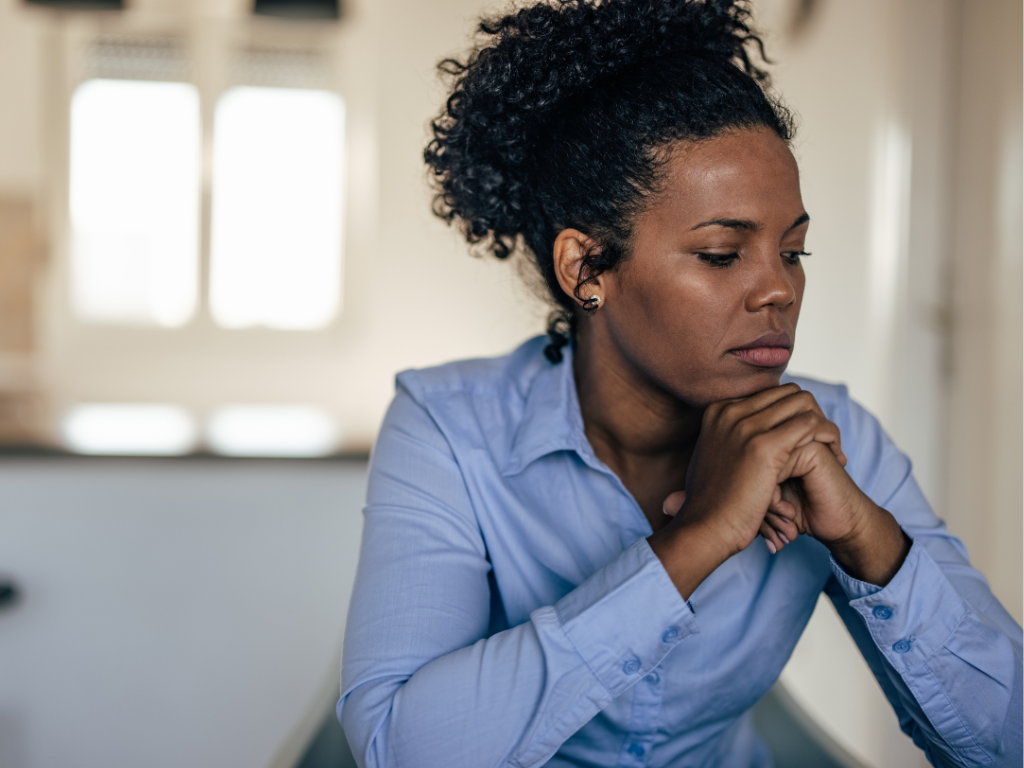 Close-up of a worried woman holding her head, symbolizing anxiety linked to perfectionism