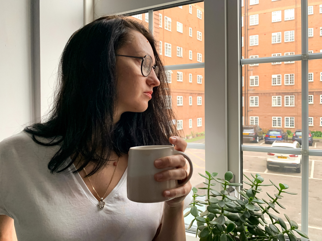 Woman deep in thought reflecting on anxiety, self-criticism, and the pressure to perform perfectly.