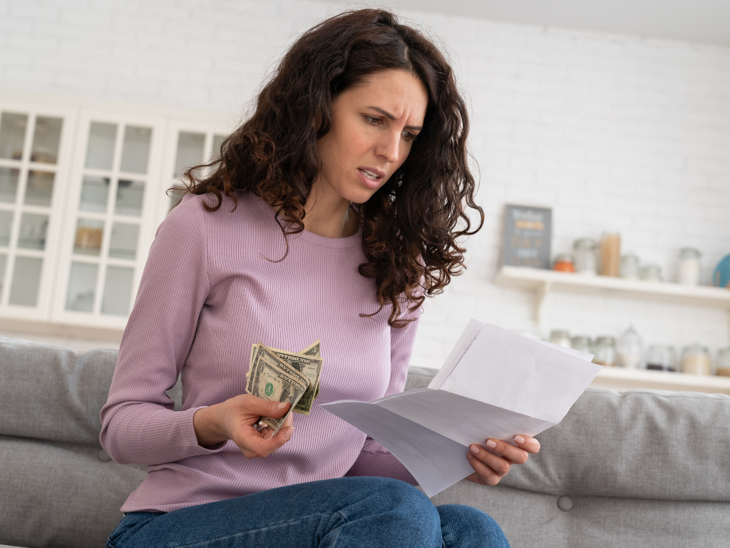 Woman reviewing financial information while noticing feelings of anxiety