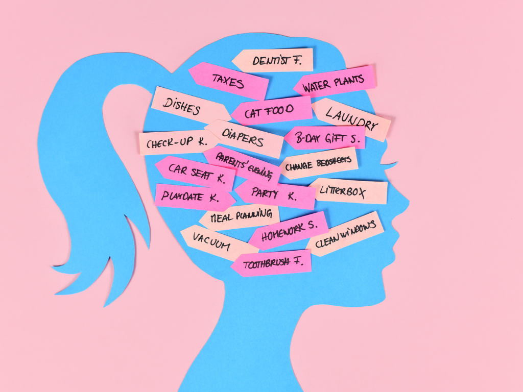 Calendar, laptop, and household reminders representing the mental load many women carry
