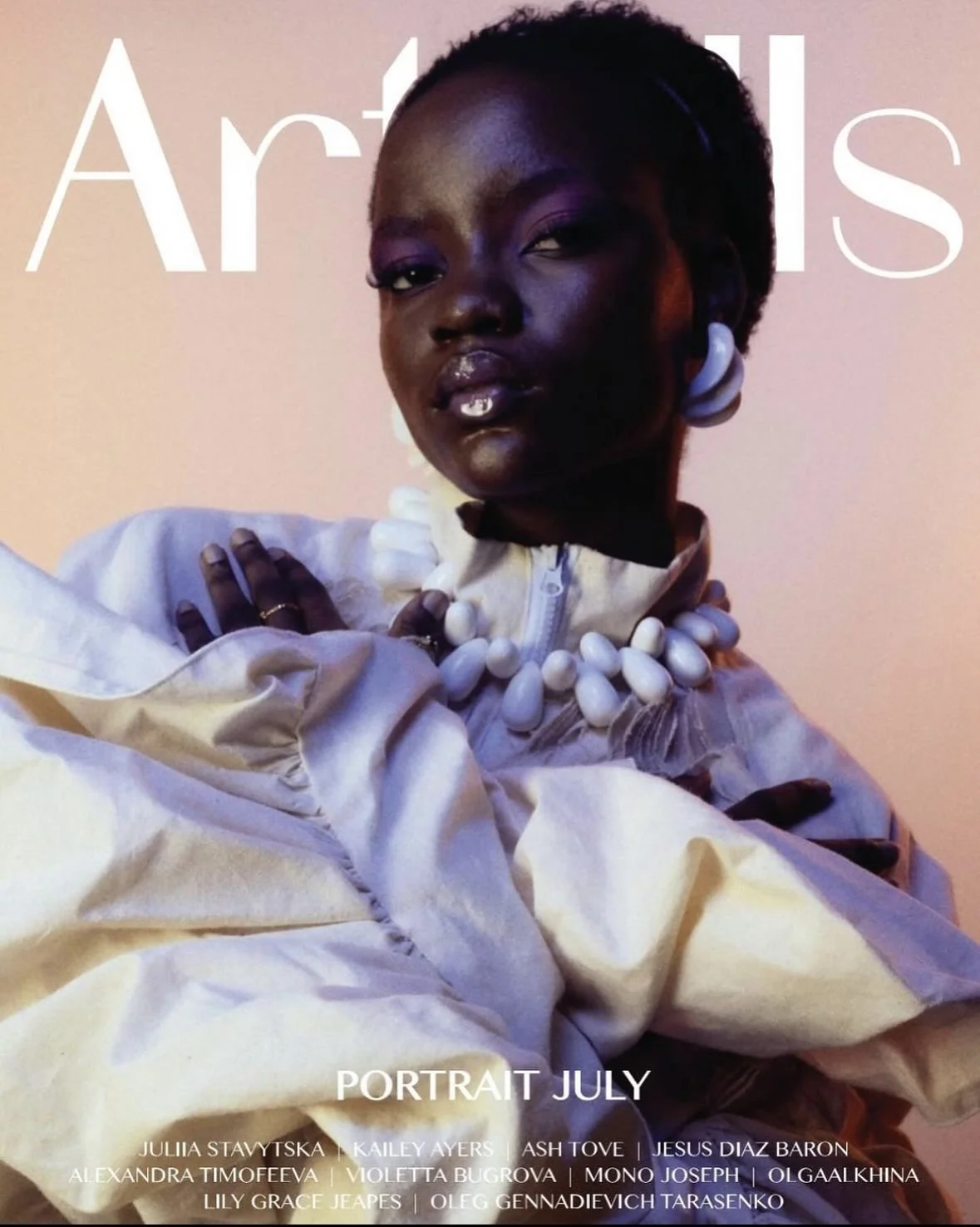 Mid shot of a young dark skin woman on a front cover magazine. Cool textural cream jacket with pink eyeshadow. 