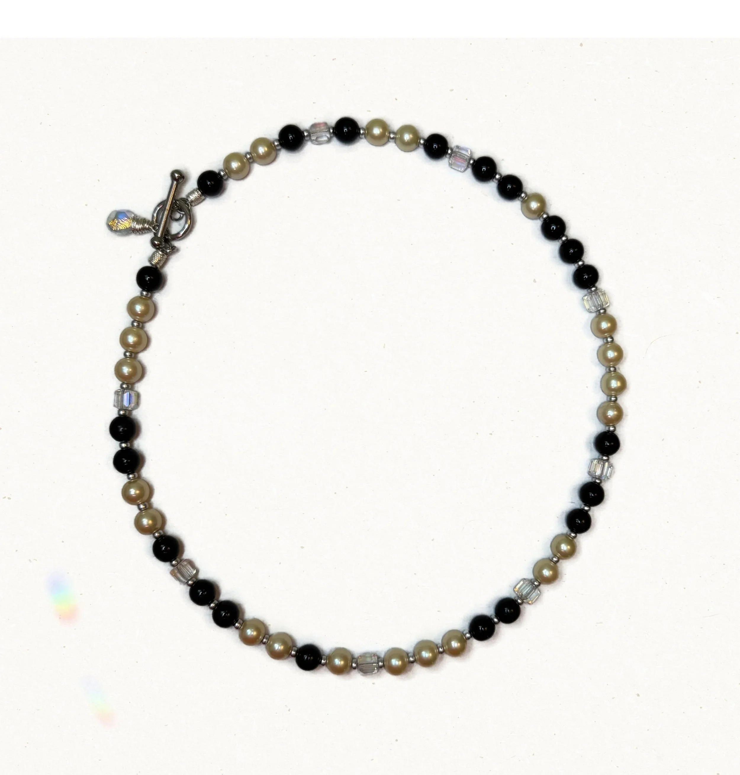 Vintage black bead and peachy pearl beaded necklace with Czech glass and toggle clasp on cream background