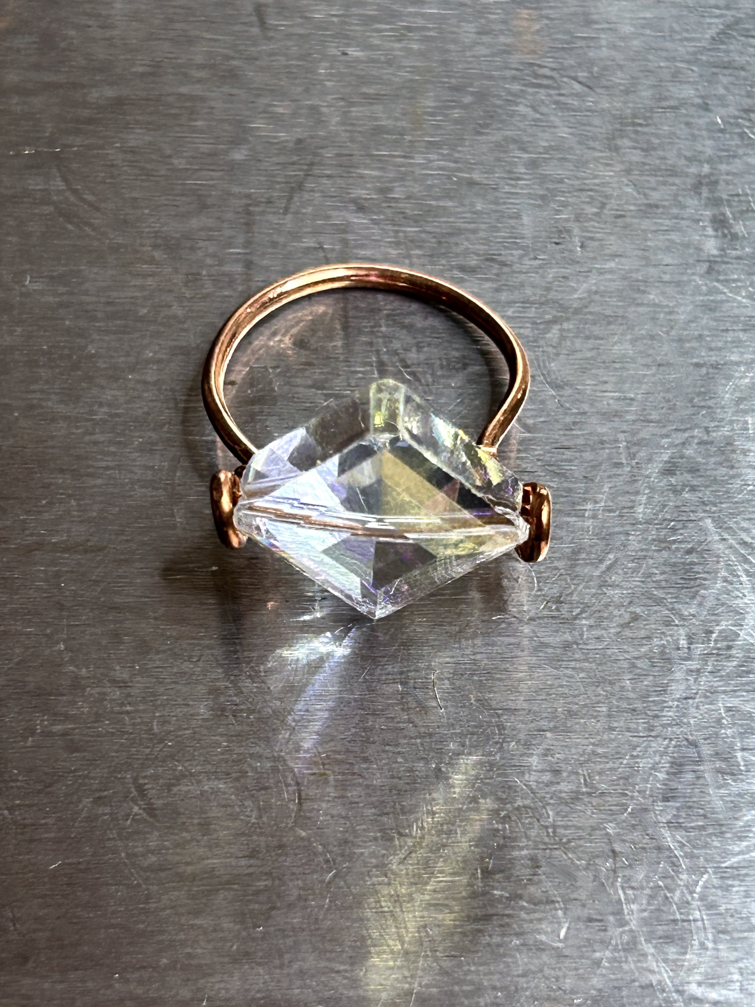 Flat Diamond Shaped Crystal and Copper Metal Viv Ring on metal block top view