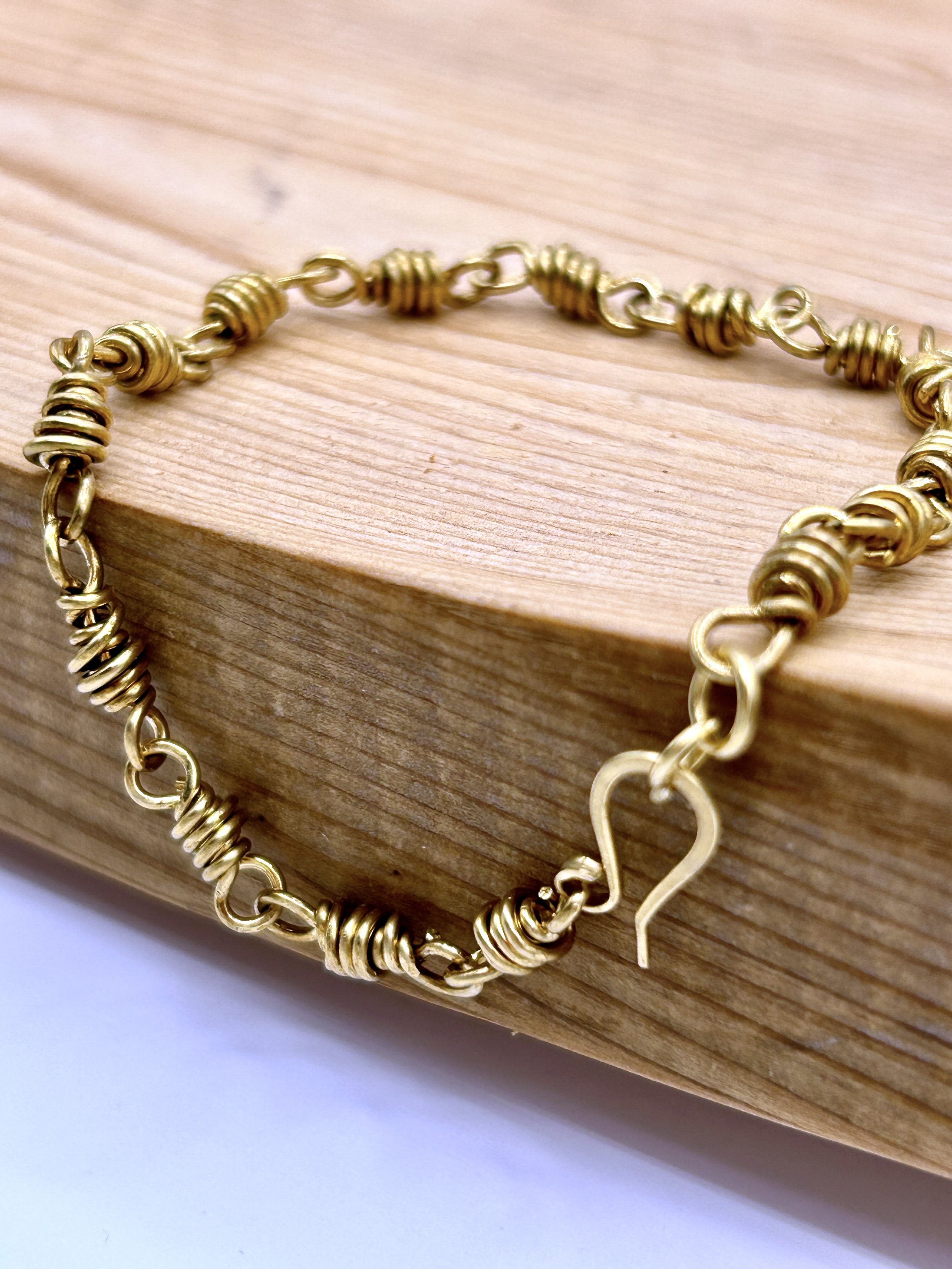 Finn Jeweler's Brass Metal Chunky Link Bracelet draped on wood