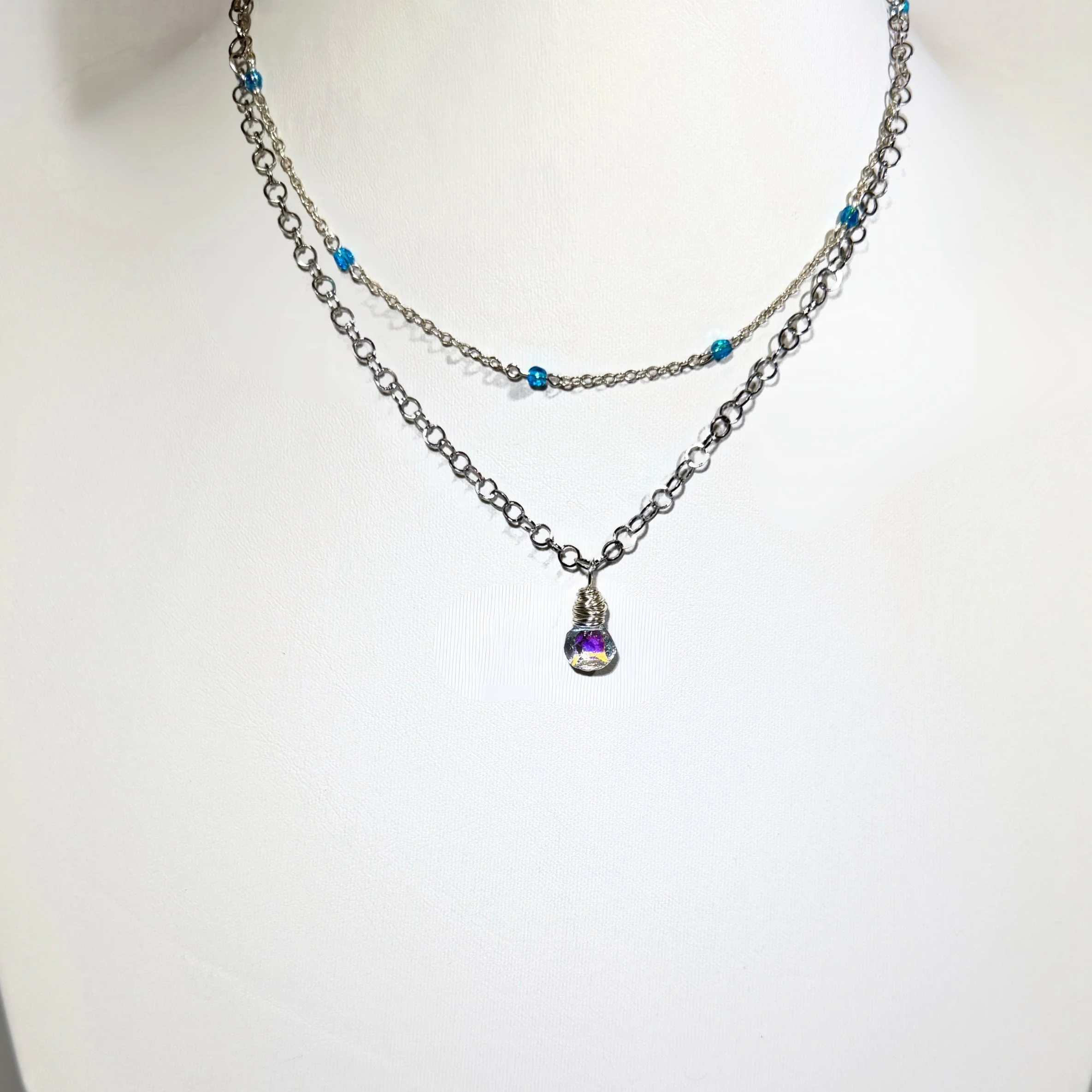 Czech glass Dew Drop Necklace with a silver-finished chain shown with Crystal Wrapped Chain Necklace on light background