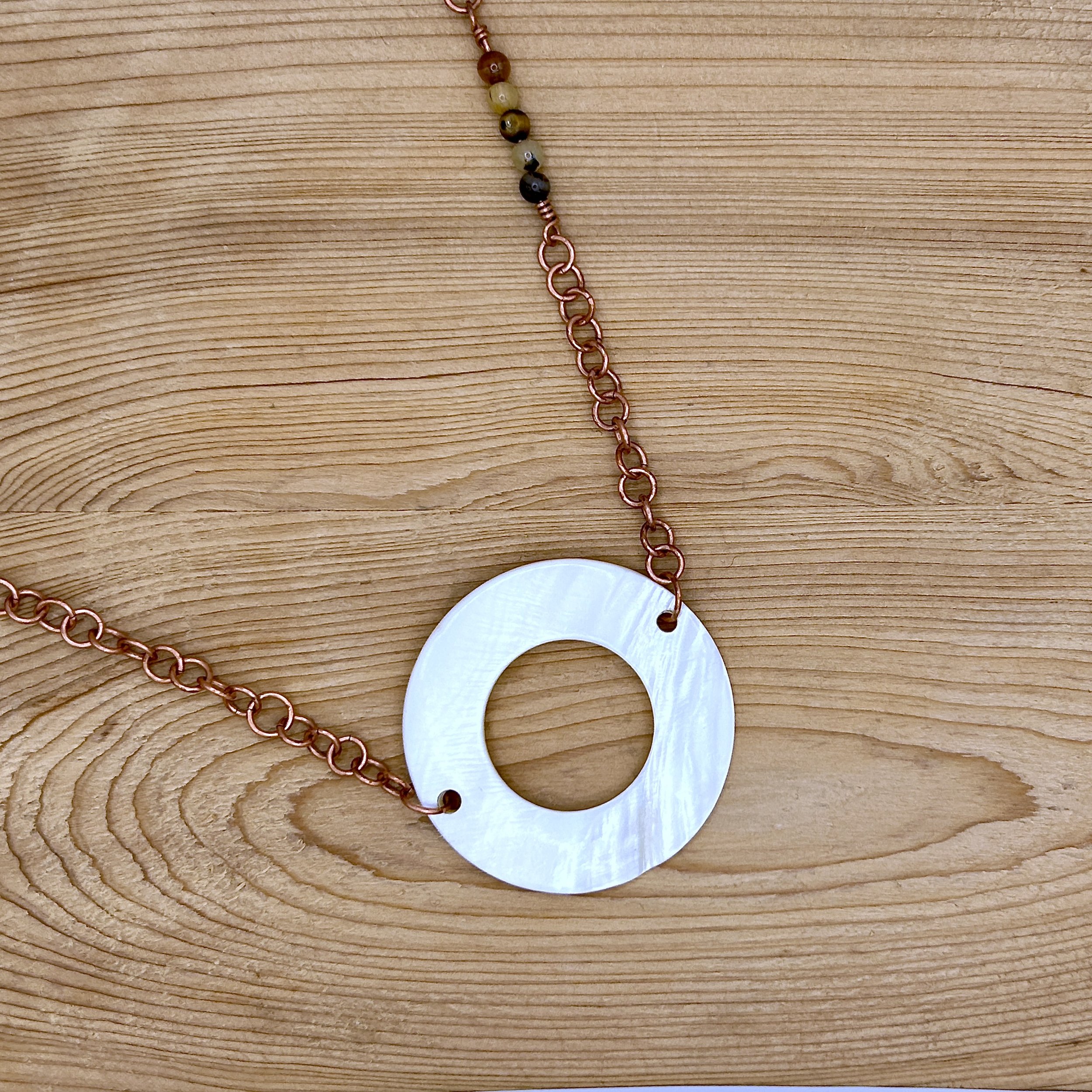 Abrial Donut Mother of Pearl on Copper Metal Link Necklace on wood