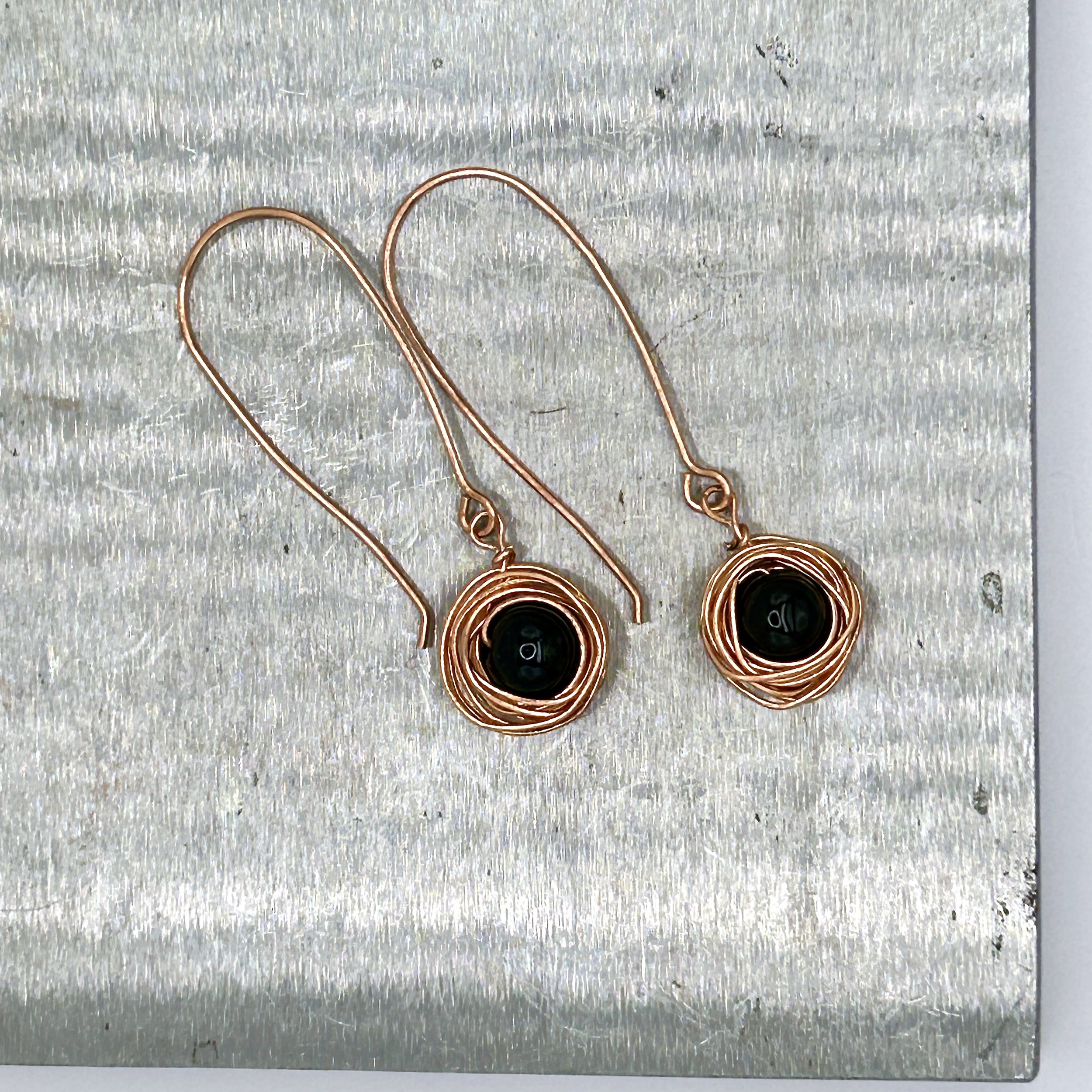 Messy Bun Earring with Black Bead nested in Copper metal and Copper metal long drop ear wires on metal block