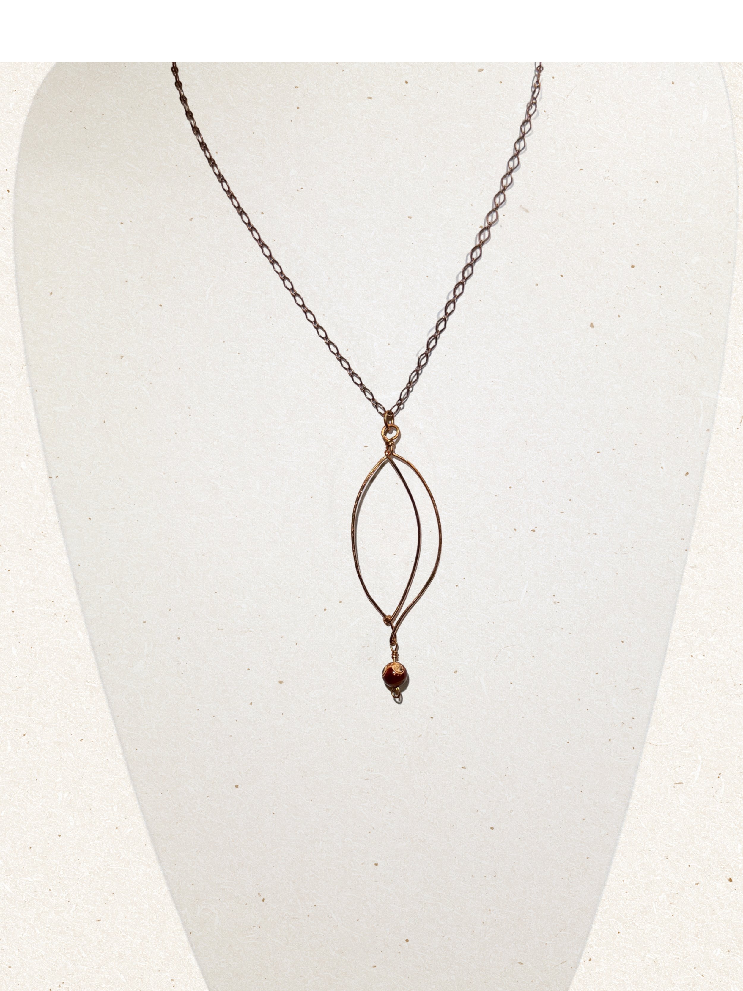 Copper sculpted leaf pendant and gemstone necklace with antiqued copper plated chain on light background