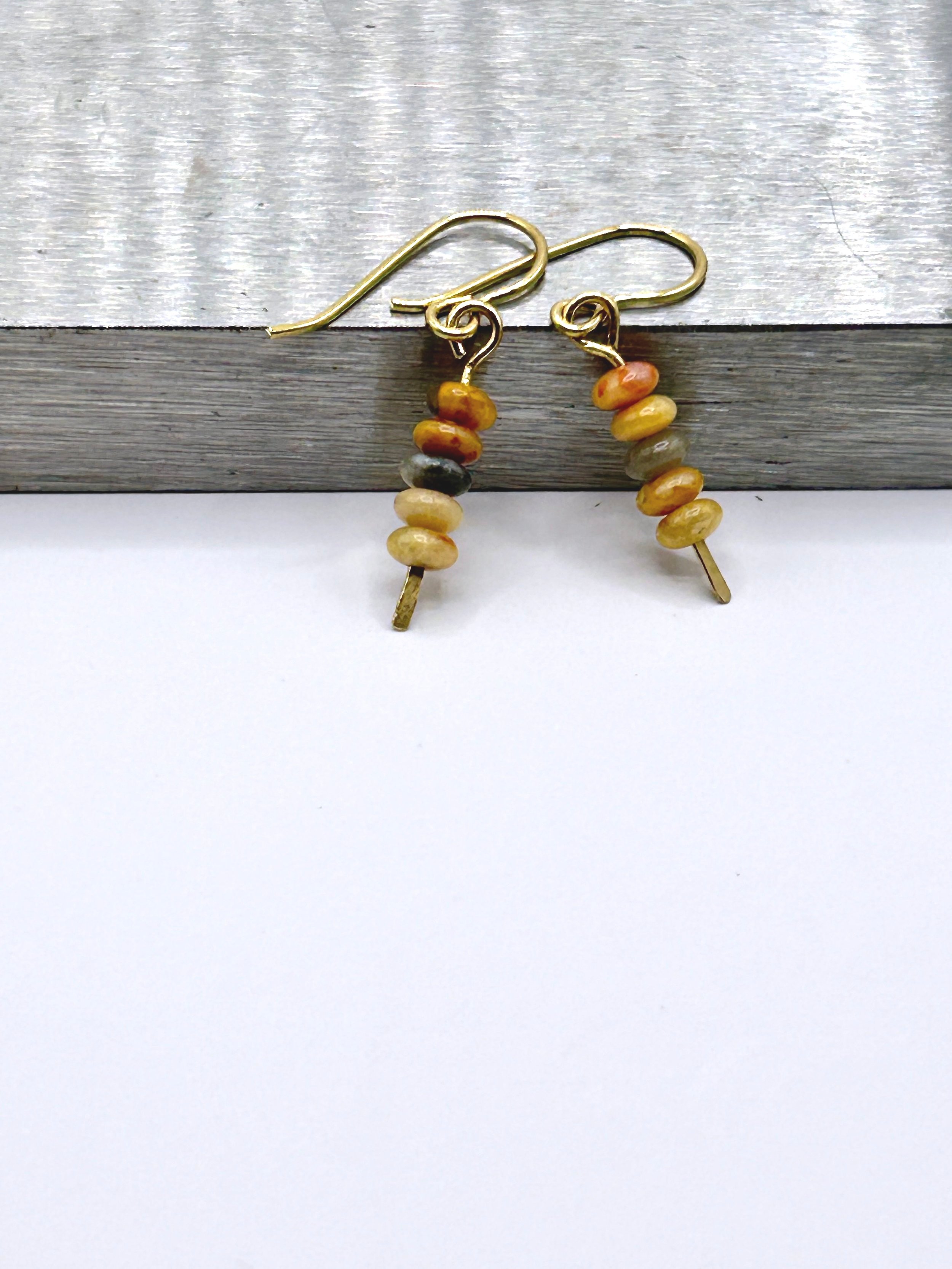 Lucy Harvest Dangle Earrings with Warm Colored Crazy Lace Agates and Jeweler's Brass french ear wires on a metal block