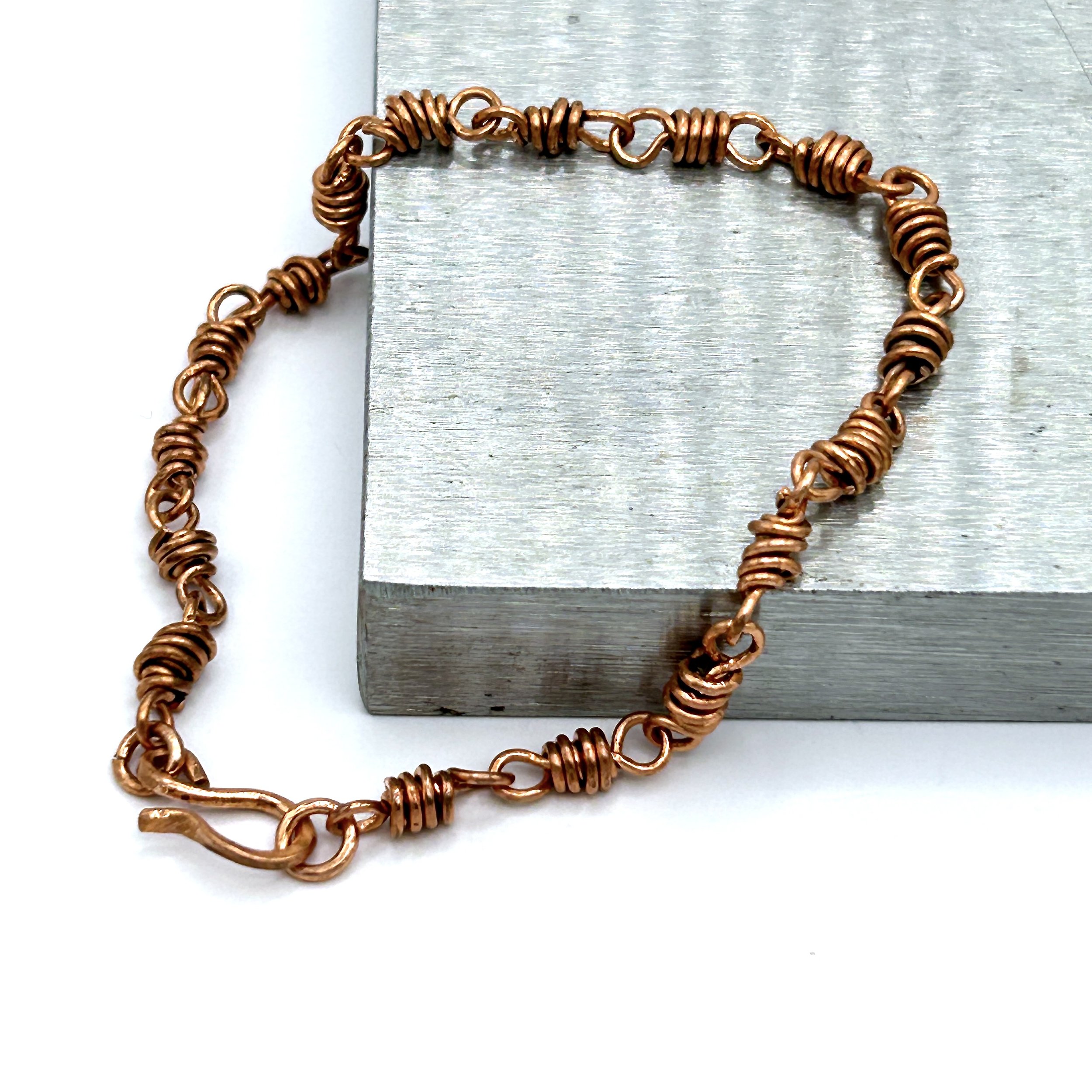 Finn Copper Metal Chunky Link Bracelet on metal block