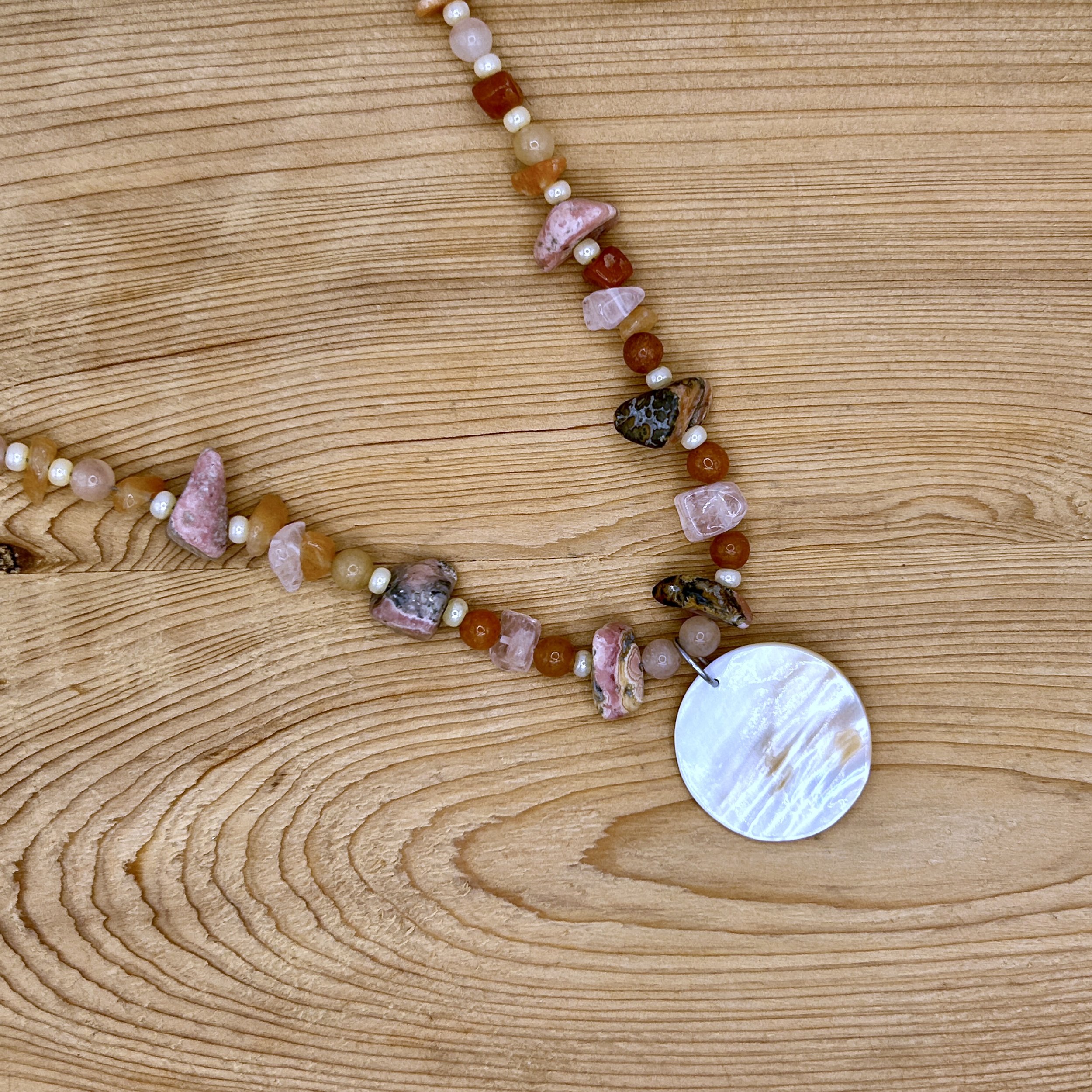 Barranca Mother of Pearl, Rhodochrosite, and beaded necklace on wood