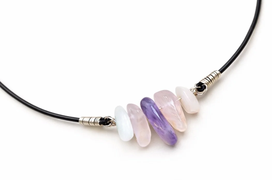 Polished gemstones on black leather cord
