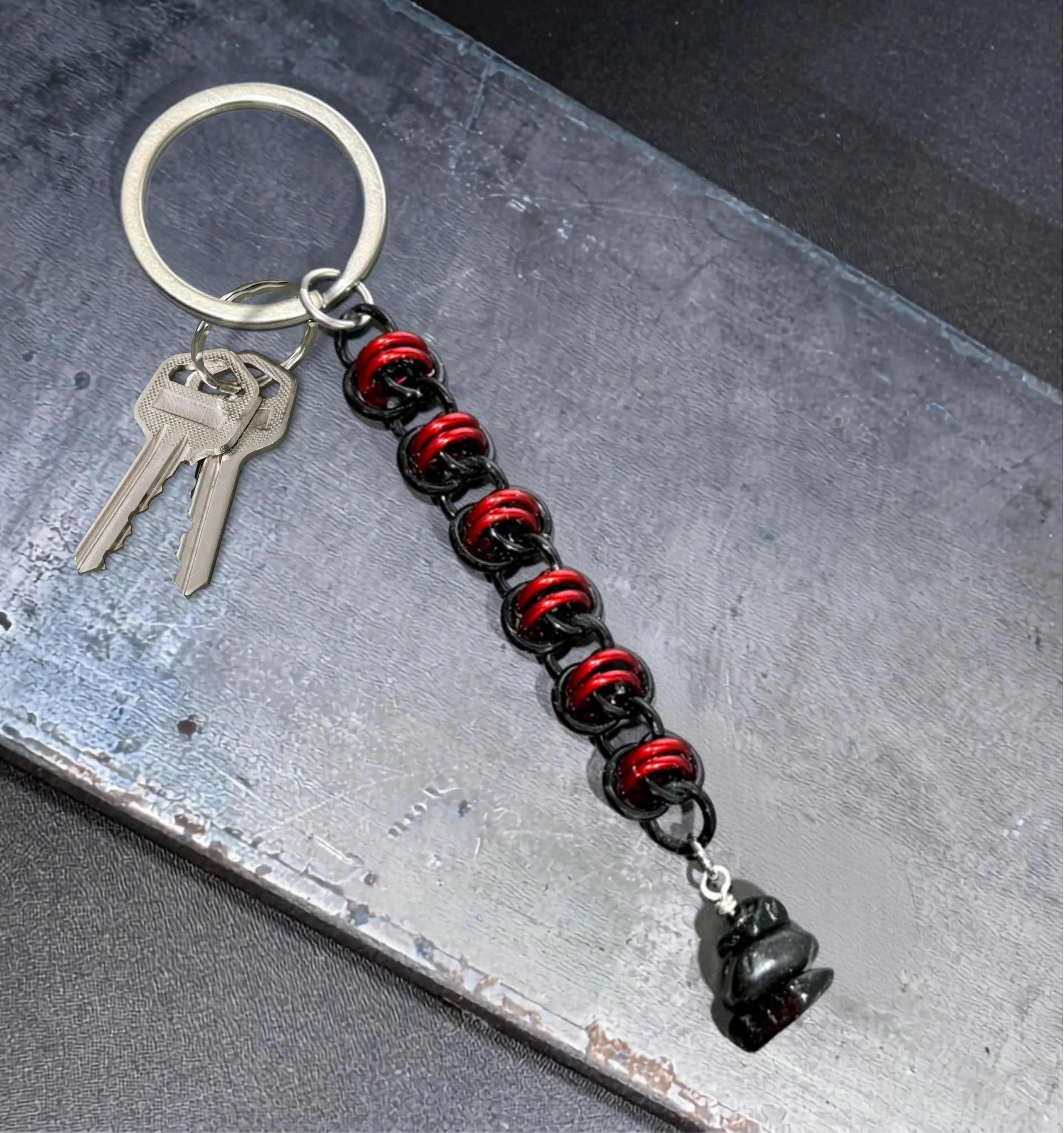 Black and red anodized aluminum keychain with polished blackstones with keys on metal