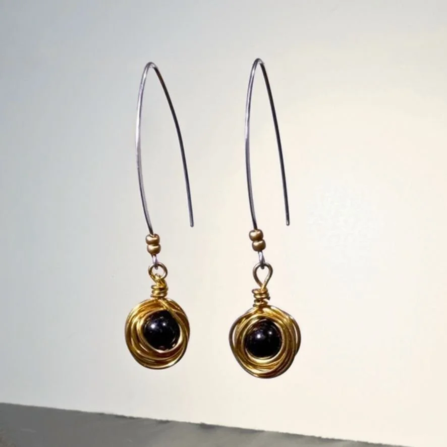 Messy Bun long drop earrings black bead nestled in jeweler's brass light background