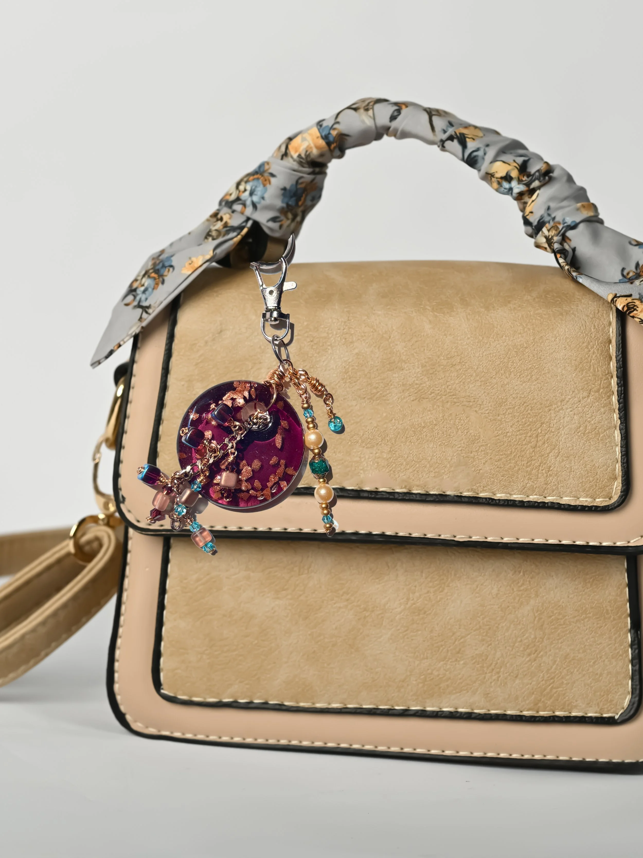 Burgundy Lampworked Copper Sparkle Bag Charm on tan handbag