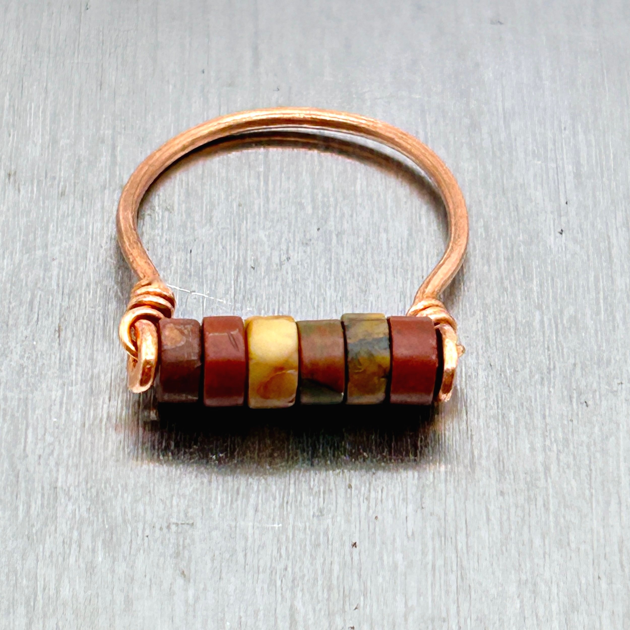 Red Jasper Beads on Copper metal ring on metal block top view