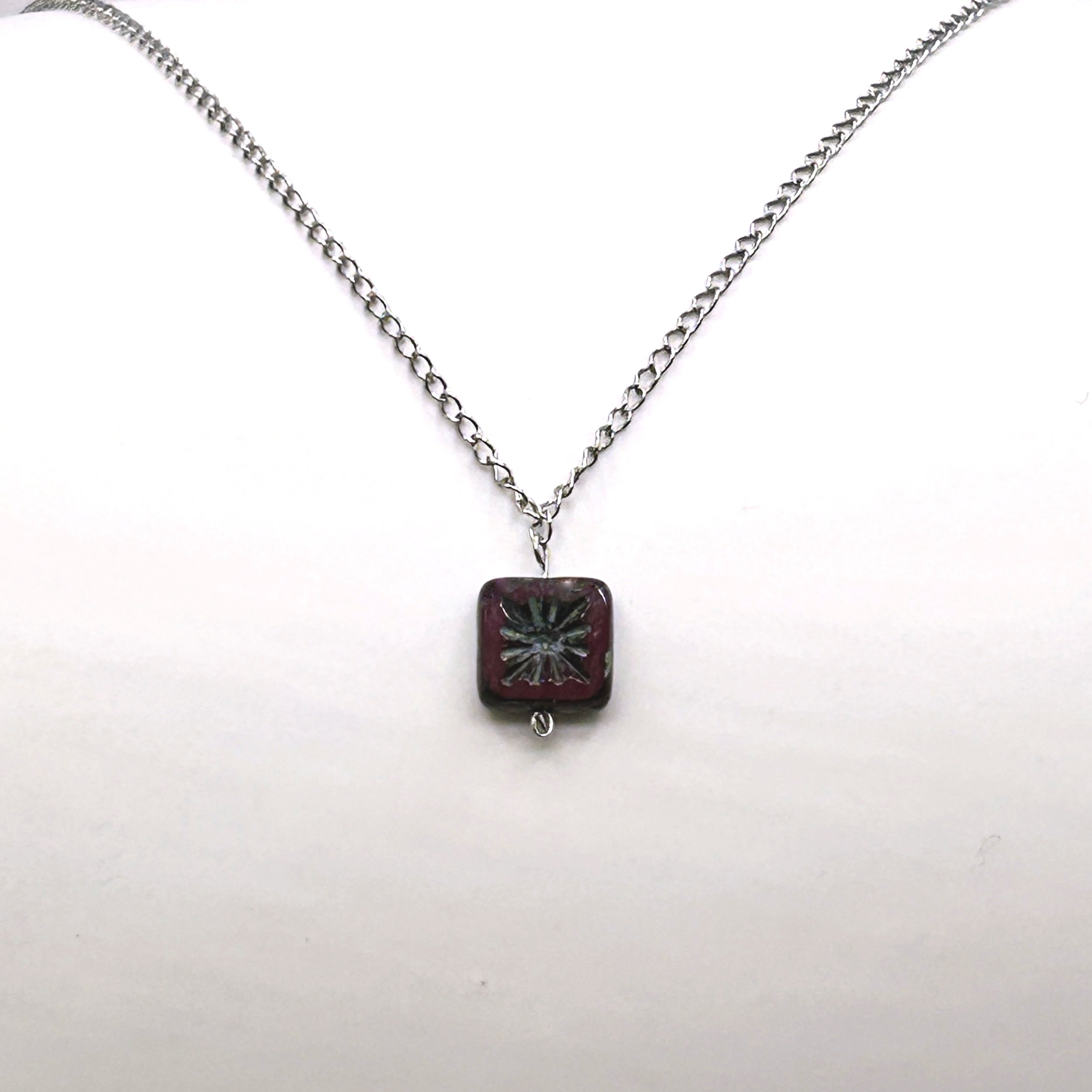 Deep Red and Silver Sunburst Czech Glass Drop Necklace on a petite stainless steel chain on a white background