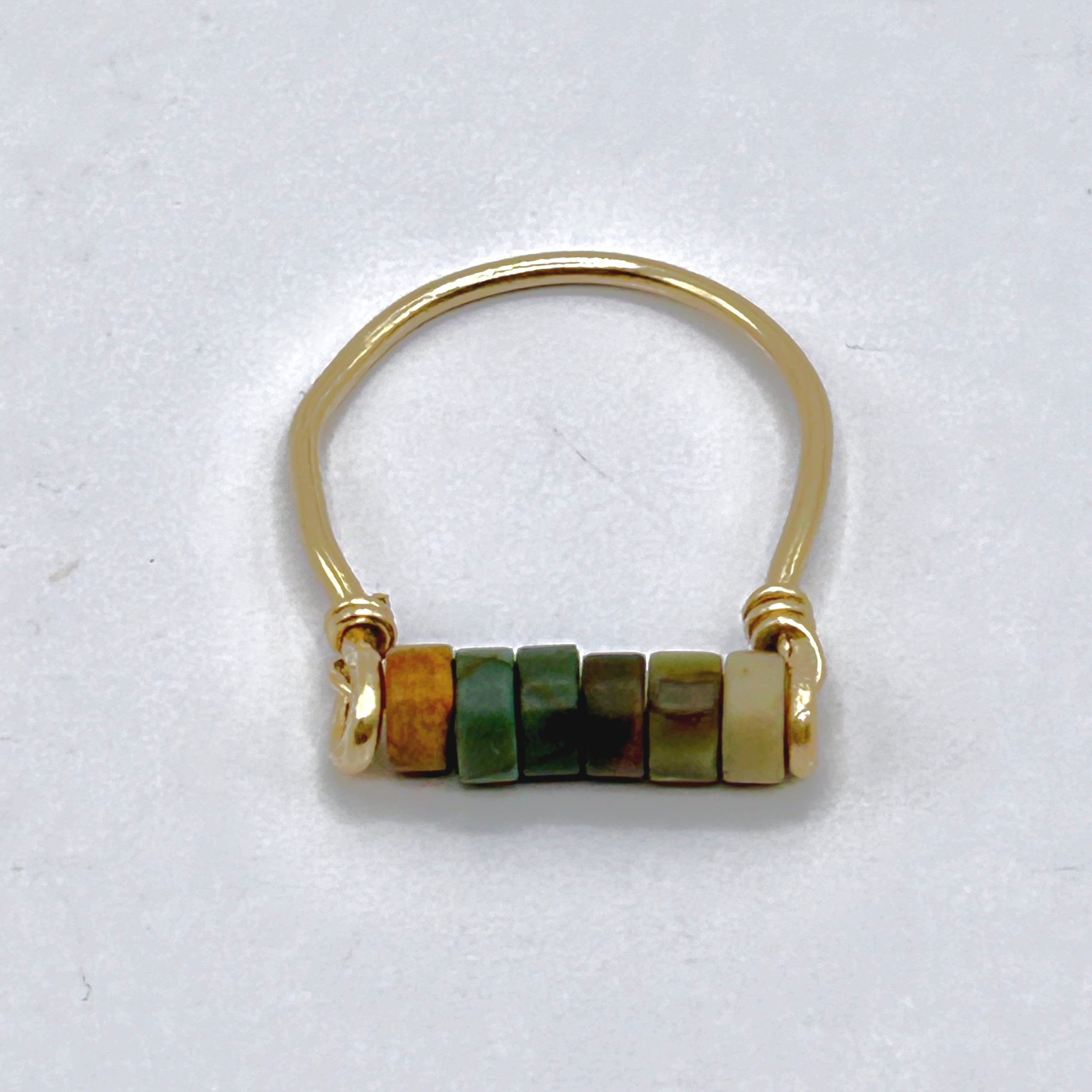 Red Jasper Beads on Jeweler's Brass metal ring on metal block top view