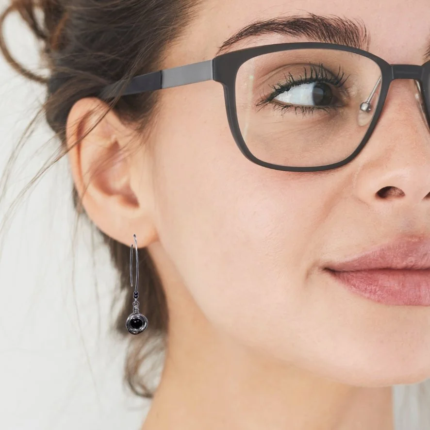 Women wearing black bead messy bun nestled in stainless steel long drop earrings