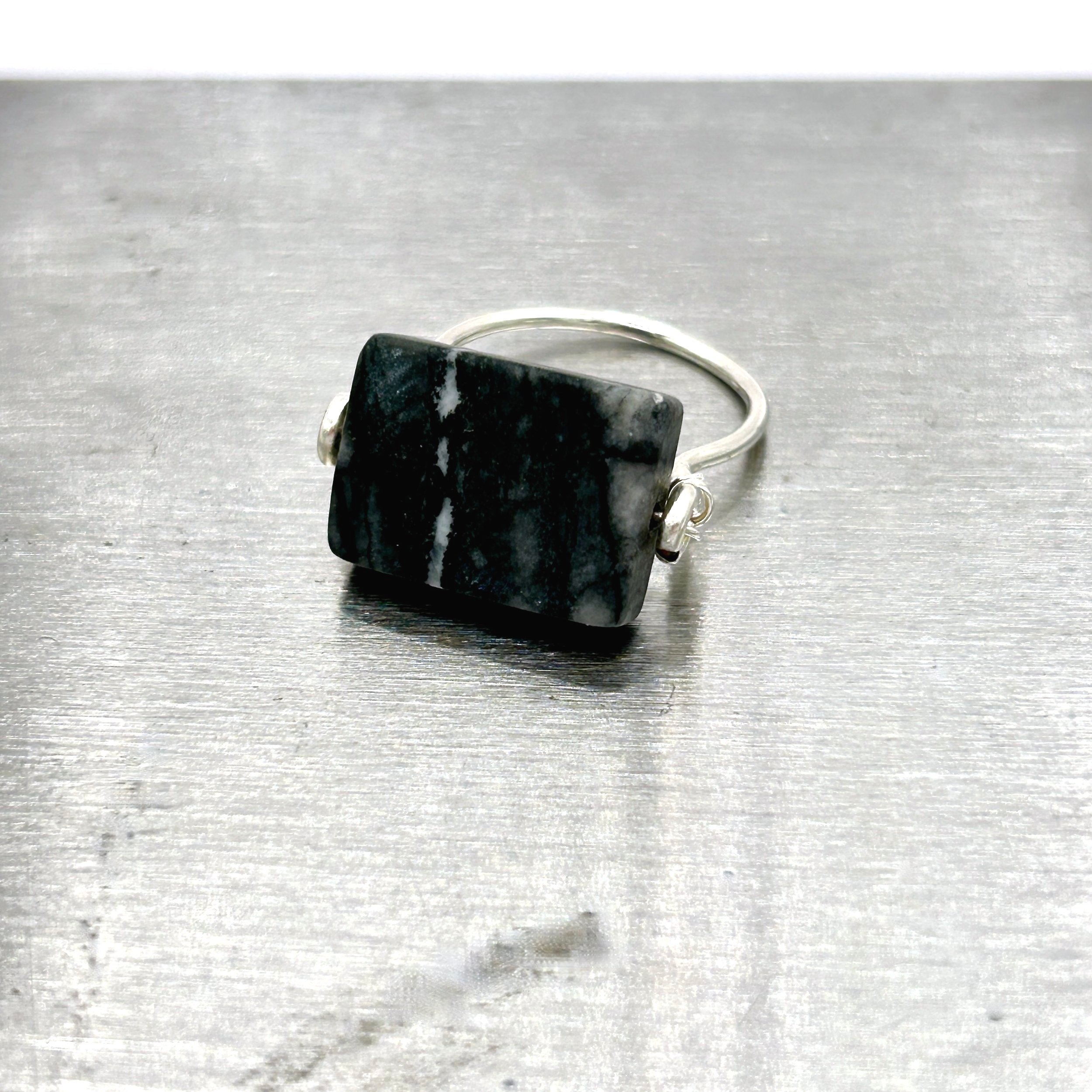 Gray Jungle Jasper rectangle stone on Sterling Silver-filled Metal Ring on metal block front view