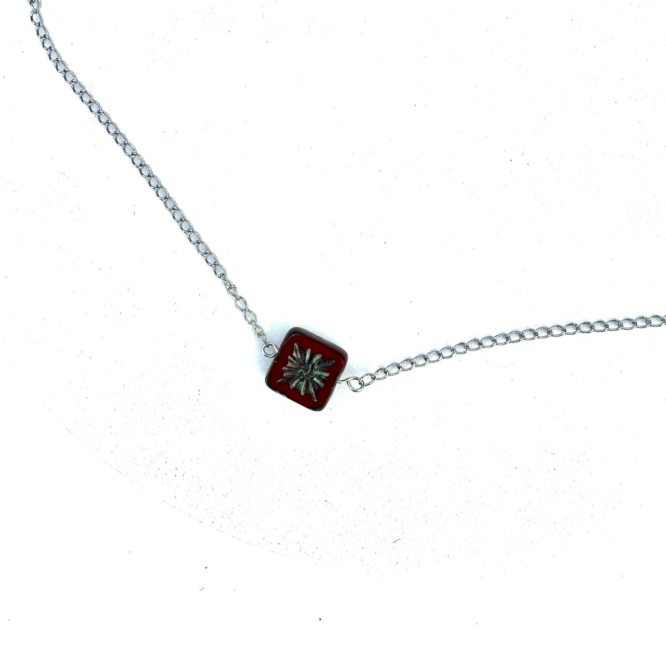 Deep Red and Silver Sunburst Czech Glass Drop Necklace on a petite stainless steel chain on a white background