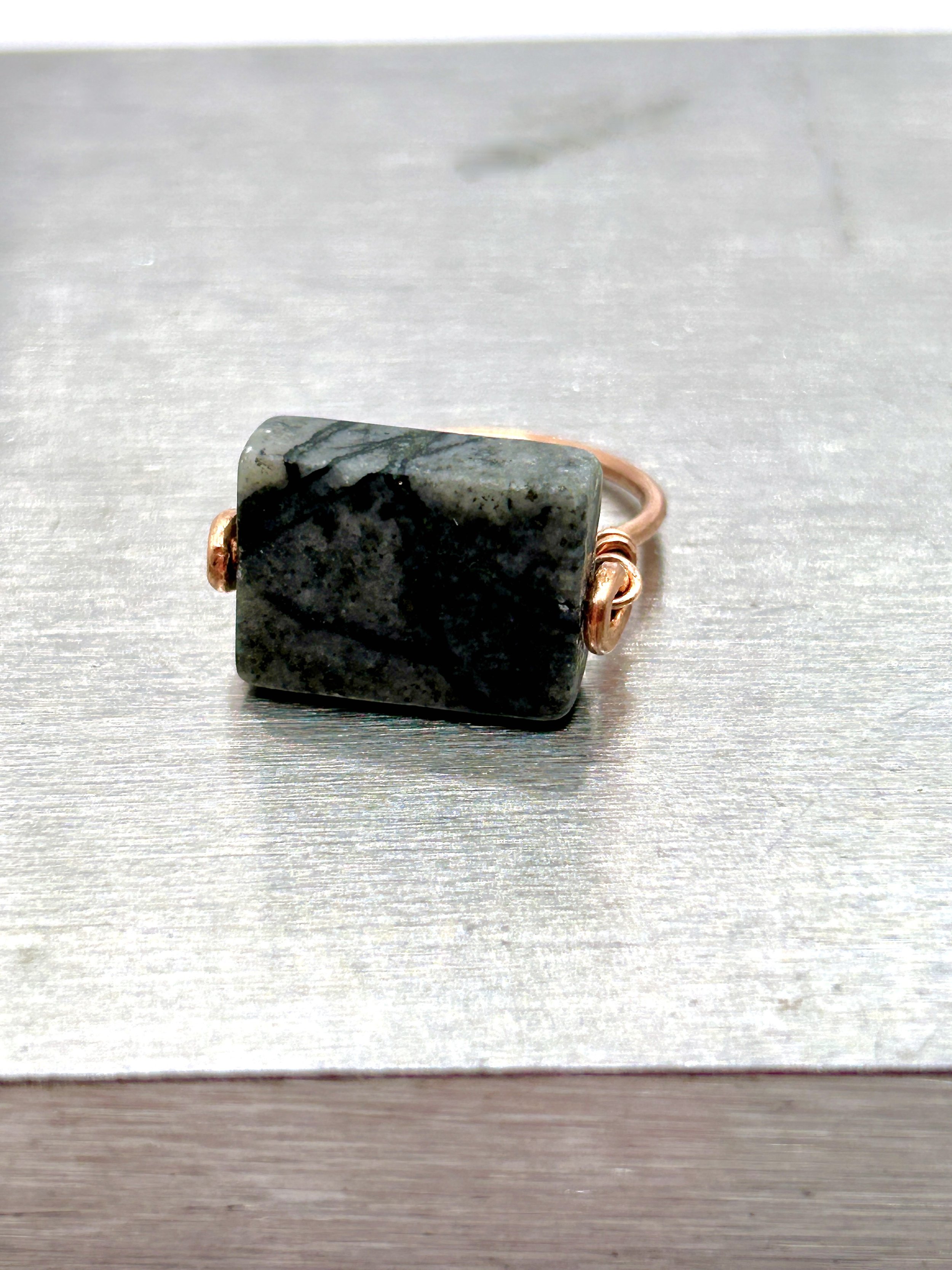 Gray Jungle Jasper rectangle stone on Copper Metal Ring on metal block front view