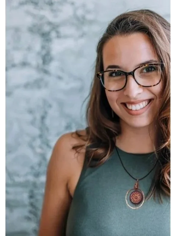 Smiling Woman Wearing Copper Sol Circle Necklace with Czech glass and Hand Formed Copper Circle on Adjustable Leather Necklace on Cream Background