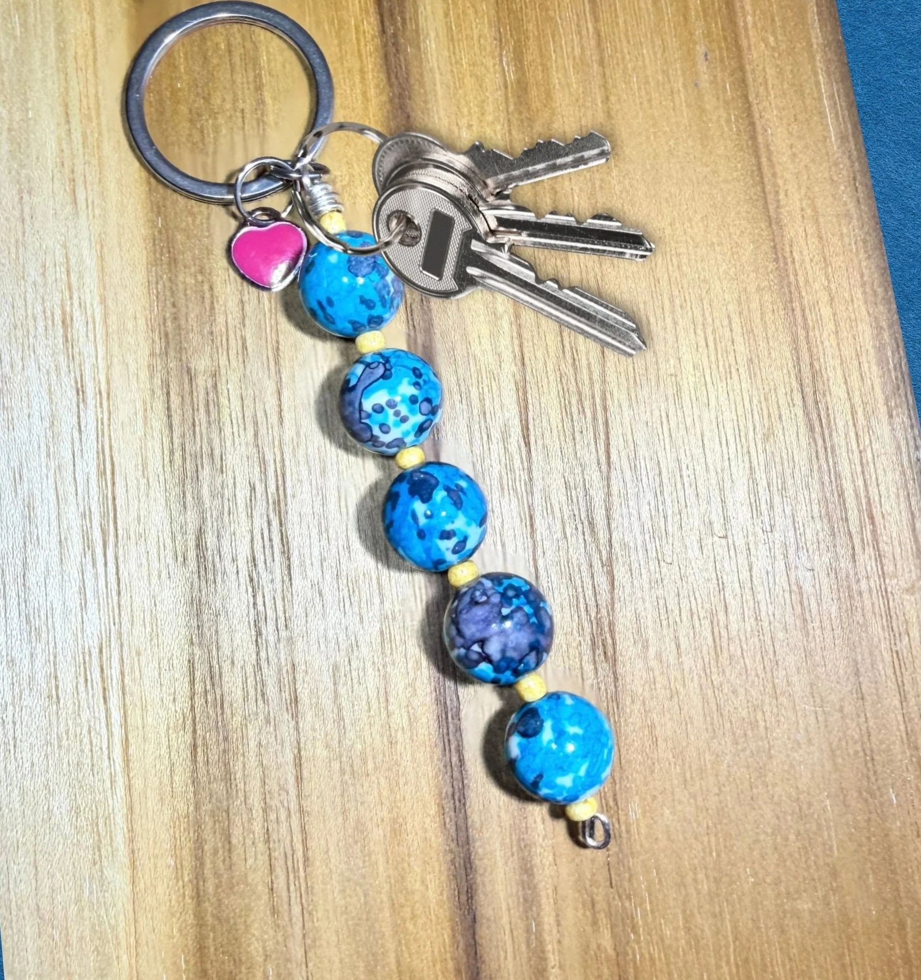 Blue Rain Flower Stone Keychain with keys on wood