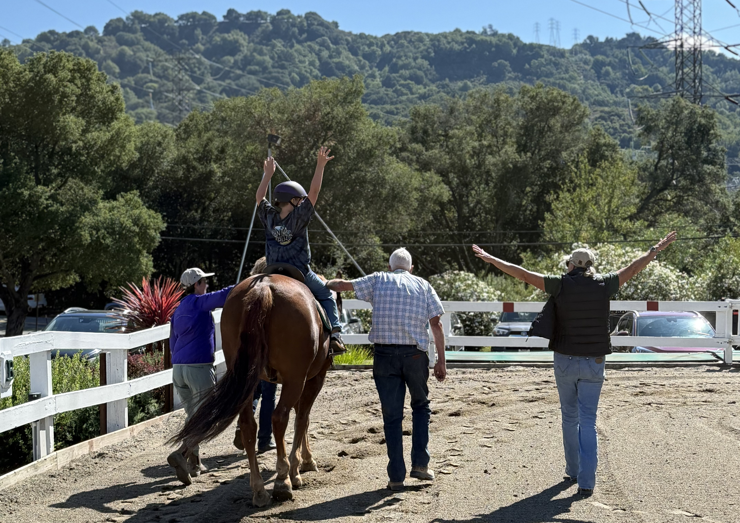 Instructor walking alongside a client riding a horse